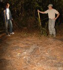 An Airman and 2nd Lieutenant Eumir Arceo, of the Fourth Communications Squadron, contemplate what to do with a sump that is going to cause a tripping hazard for children when they go through the haunted trail behind Kimpo Park here on Seymour Johnson Air Force Base. The haunted trail will run from Oct. 28 to 31 from 7 to 10 p.m. (U.S. Air Force Photo by Airman 1st Class Rae A. Perry)