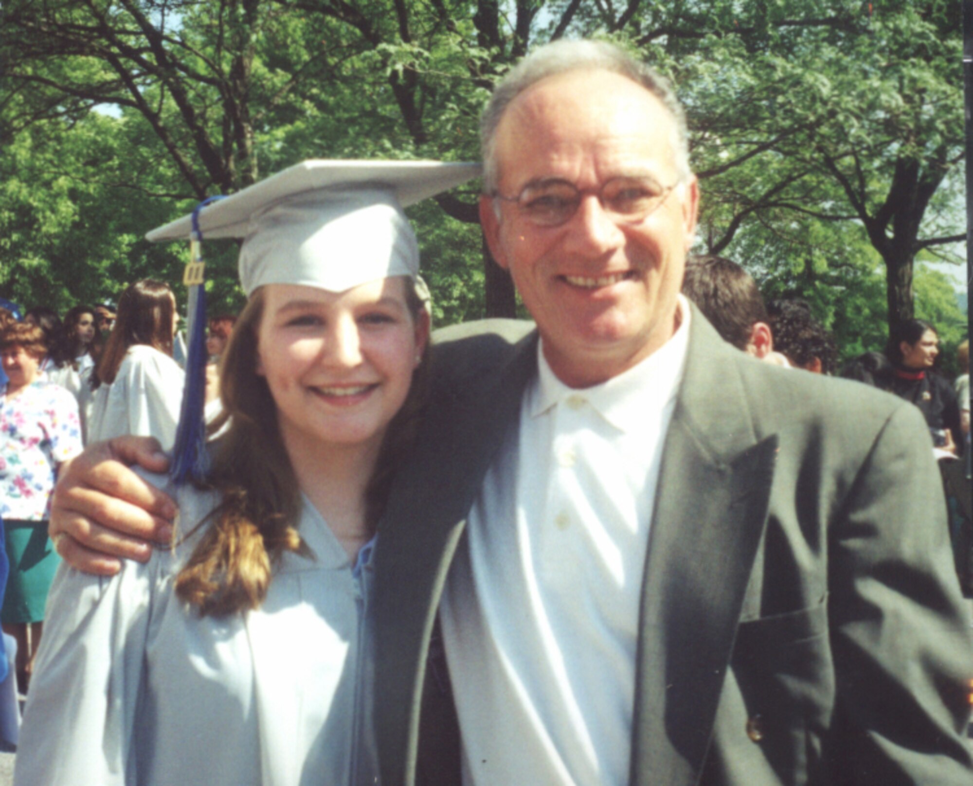 (Left) Kimberly Hollowell stands with Maj. Jose Troche, her AFJROTC instructor, during her 2001 high school graduation ceremony.