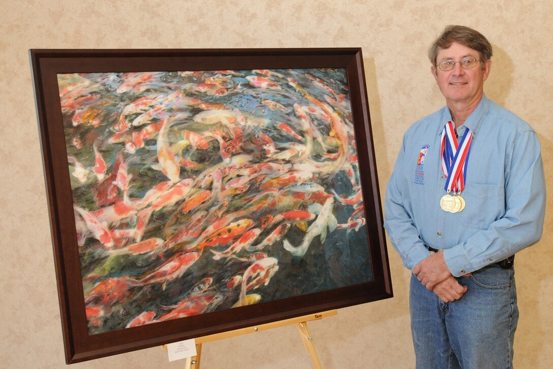 Retired Air Force Lt. Col. Dennis Linn, a veteran of Operation Enduring Freedom who suffers from cardiovascular disease, said art has always been a therapeutic outlet. One of more than 120 disabled veterans participating in the National Veterans Creative Arts Festival, Linn poses with his painting, “Koi.” Department of Veterans Affairs photo by Gene Davies