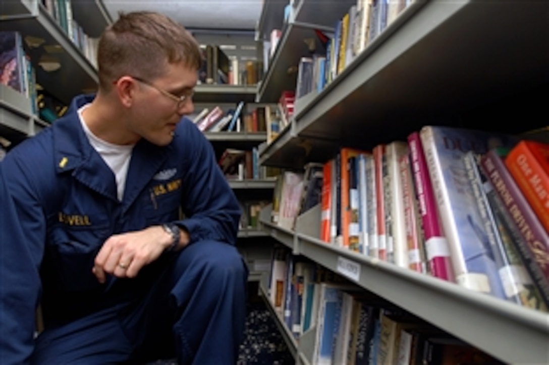 U.S. Navy Ensign Jason Lovell searches for a book in the ship's library aboard the aircraft carrier USS Theodore Roosevelt, Gulf of Oman, Oct. 18, 2008. The Nimitz-class aircraft carrier and embarked Carrier Air Wing 8 are under way on a regularly scheduled deployment. 
