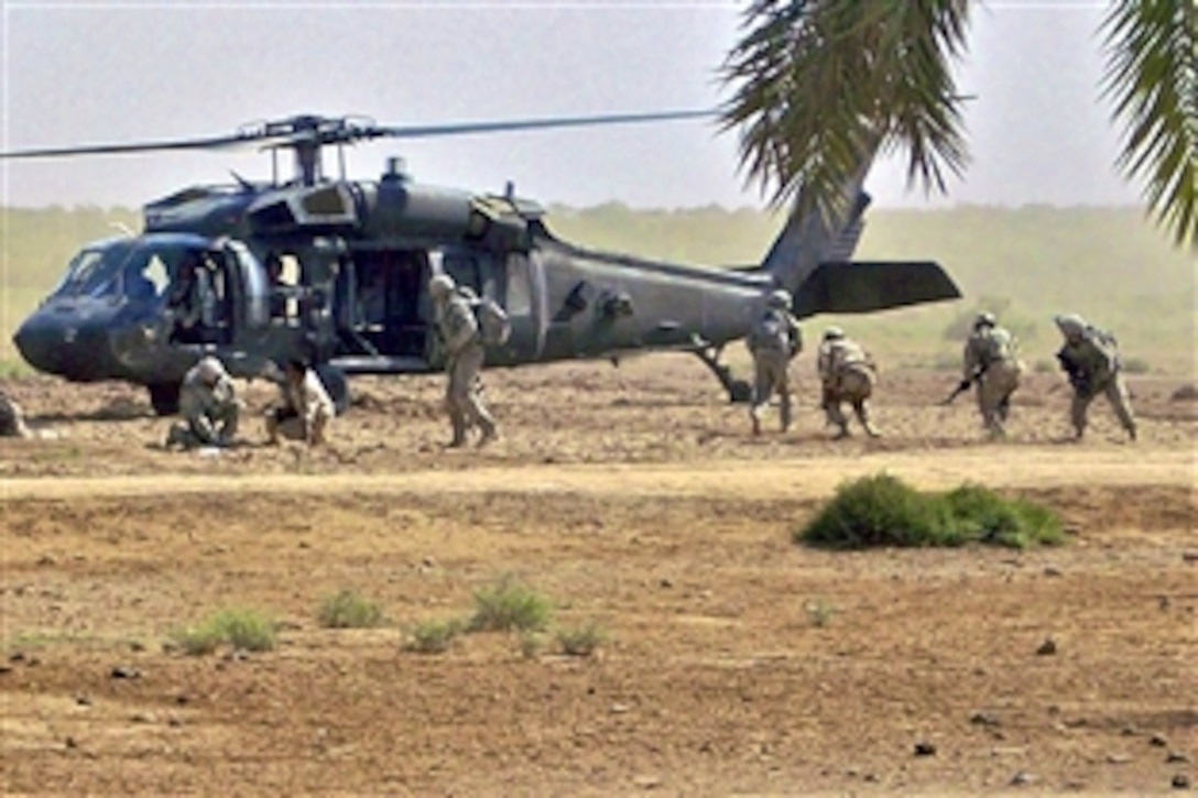 U.S. and Iraqi soldiers dismount a UH-60 Black Hawk helicopter during an air assault near Amarah, Iraq, Oct. 18, 2008. The U.S. soldiers are assigned to the 1st Cavalry Division's 5th Battalion, 82nd Field Artillery Regiment, 4th Brigade Combat Team.