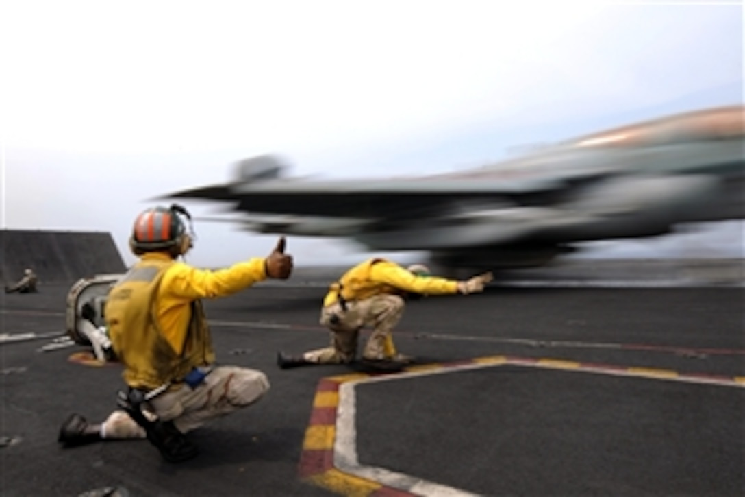 U.S. Navy Lt. Cmdr. Charles Prim gives the thumbs up sign as Lt. Douglas Steil gives the signal to launch, or "shoot," an EA-6B Prowler off of a catapult on the USS Ronald Reagan, under way in the Indian Ocean, Oct. 21, 2008. Prim is training Steil to be a "shooter," the nickname given to those who signal aircraft launches.
 
