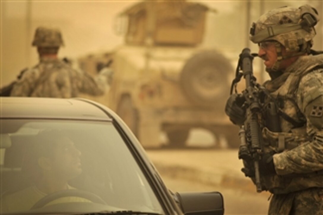 U.S. Army Sgt. Robert Griffin, a medic attached to the 4th Infantry Division, checks vehicles during a security checkpoint mission with Iraqi soldiers in Abu T'Shir, Iraq, on Oct. 16, 2008.  