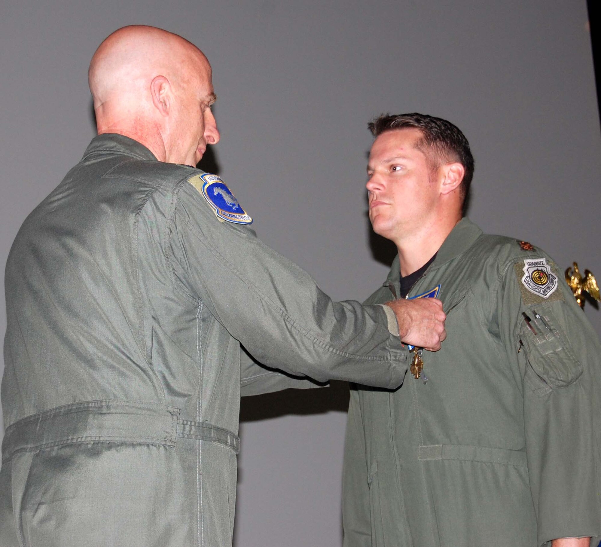 Col. Michael Newman, (left), 51st Operations Group commander, pins the Distinguished Flying Cross medal on Maj. Daniel Clayton, 51st Operations Group chief of standardization and evaluation, during a ceremony Oct. 17. Major Clayton, an A-10 pilot, earned the medal for his actions and leadership during a combat search and rescue operation. (U.S. Air Force photo/Staff Sgt. Lakisha Croley)