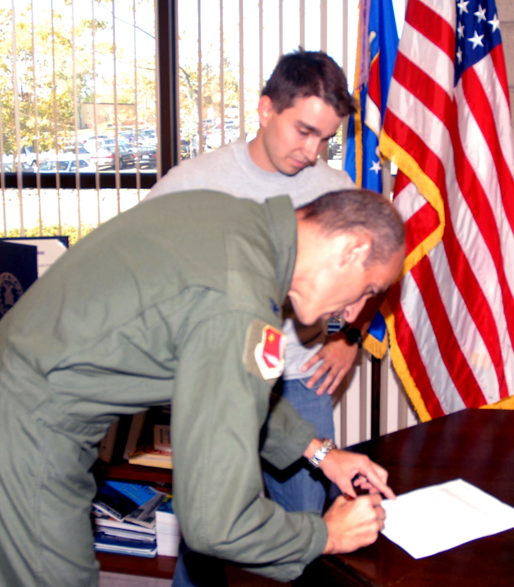 BEALE AIR FORCE BASE, Calif. -- Air Force Reservist, Col. Jeff "Sal" Mineo, signs enlistment papers for Jason Nuttall Oct. 10, 2008. Jason was Col. Mineo's first swearing in as wing commander for the 940th Air Refuleing WIng here. A fire fighter for the city of Oroville, Calif., Jason is scheduled to depart for basic training at Lackland AFB, Texas, Dec. 30. Upon completion of basic, he reports for further schooling to San Angelo, Texas, and then returns for Reserve duty at the 940th. (U.S. Air Force photo/MSgt. Ellen L. Hatfield)