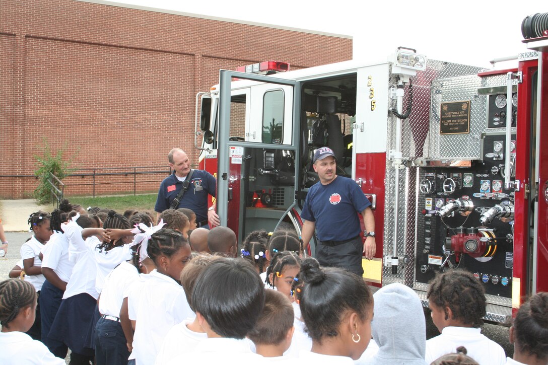 Tech. Sgt. Keith O’Daniel, air transportation specialist with 89th Aerial Port Squadron and volunteer Forestville firefighter, speaks with a group of fourth graders at James Ryder Randall Elementary School in Clinton, Md during fire prevention week Oct. 16, 2007. Sergeant O’Daniel explained how the pump operates on Engine 235, a 2004 Pierce Enforcer. (Courtesy photo)