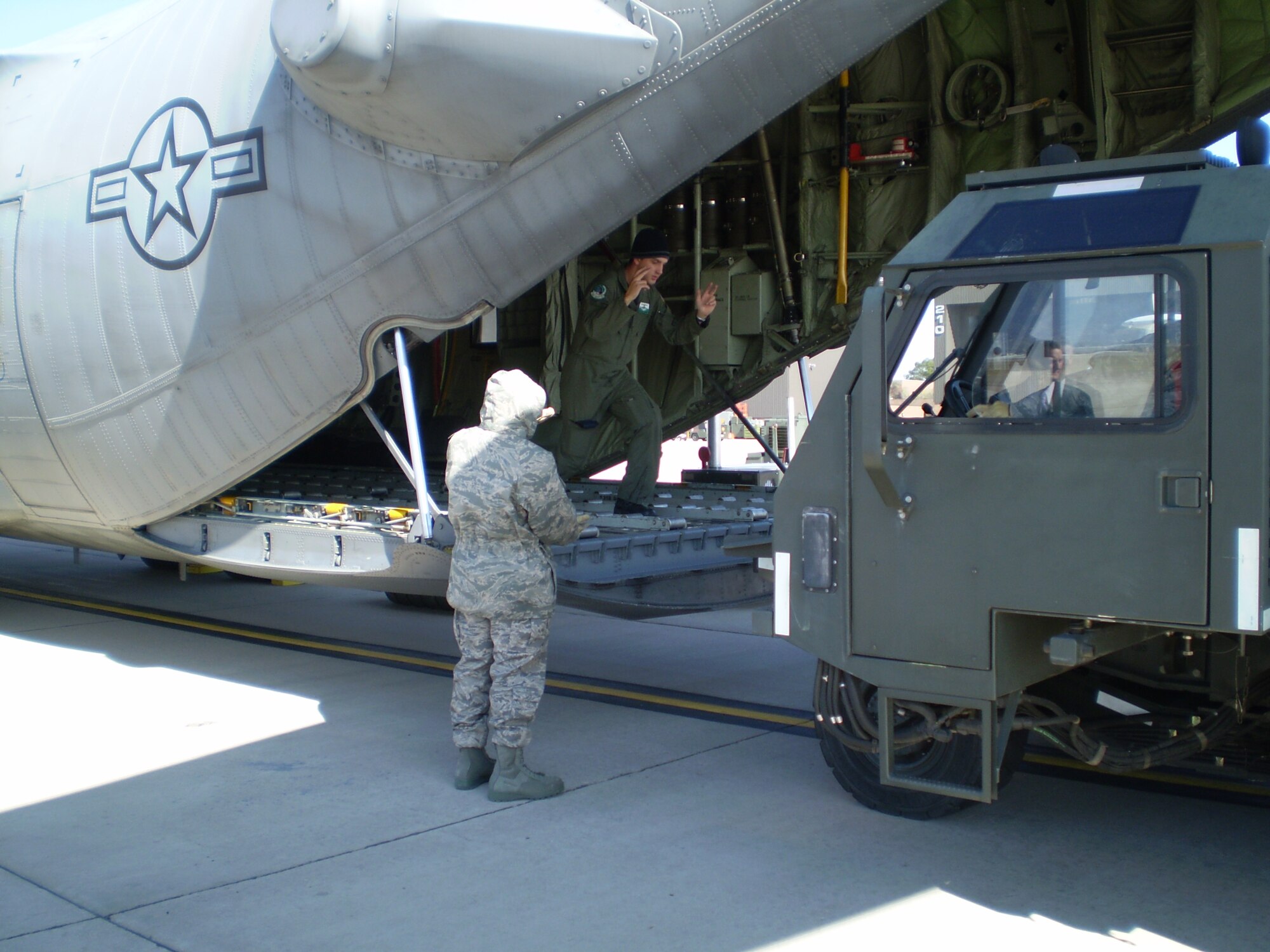Members of the 21st Space Wing and 302nd Airlift Wing work together to practice loading equipment into a C-130 aircraft as part of a mock deployment for the 21st SW's Condor Crest 09-01 exercise (Air Force photo/Staff Sgt. Stacey Haga) 