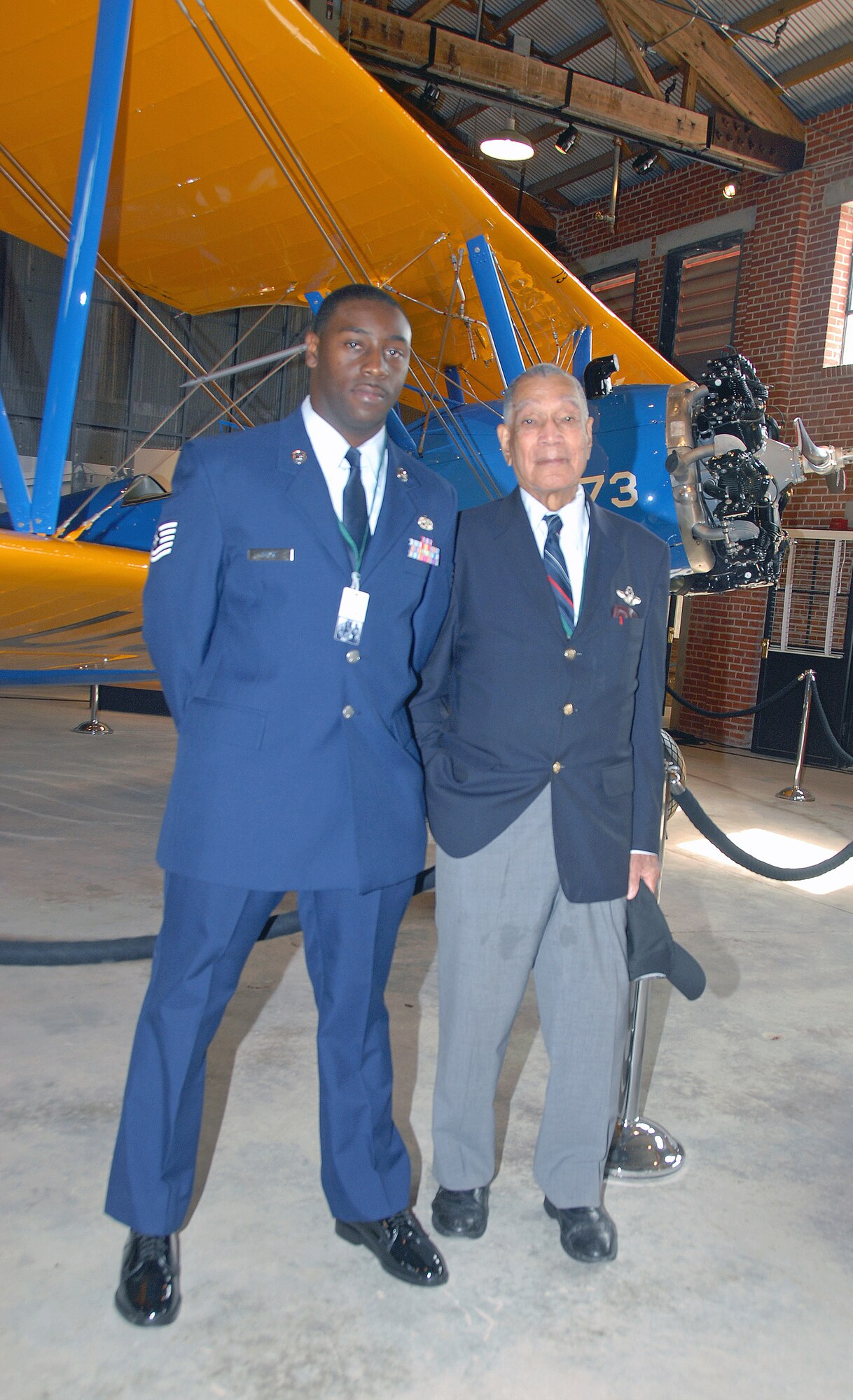 Tech. Sgt. D'Wayne Guice poses for a keepsake photo with retired Lt. Col. Lee "Buddy" Archer in front of the Stearman PT-17 trainer exhibit on display at the Tuskegee Airmen National Historic Site. Colonel Archer registered five confirmed enemy kills to become the only Tuskegee Airman "Ace" during WWII. Sergeant Guice is a member of the 908th Airlift Wing at nearby Maxwell AFB, Ala. (U.S. Air Force Photo by Lt. Col. Jerry Lobb)         