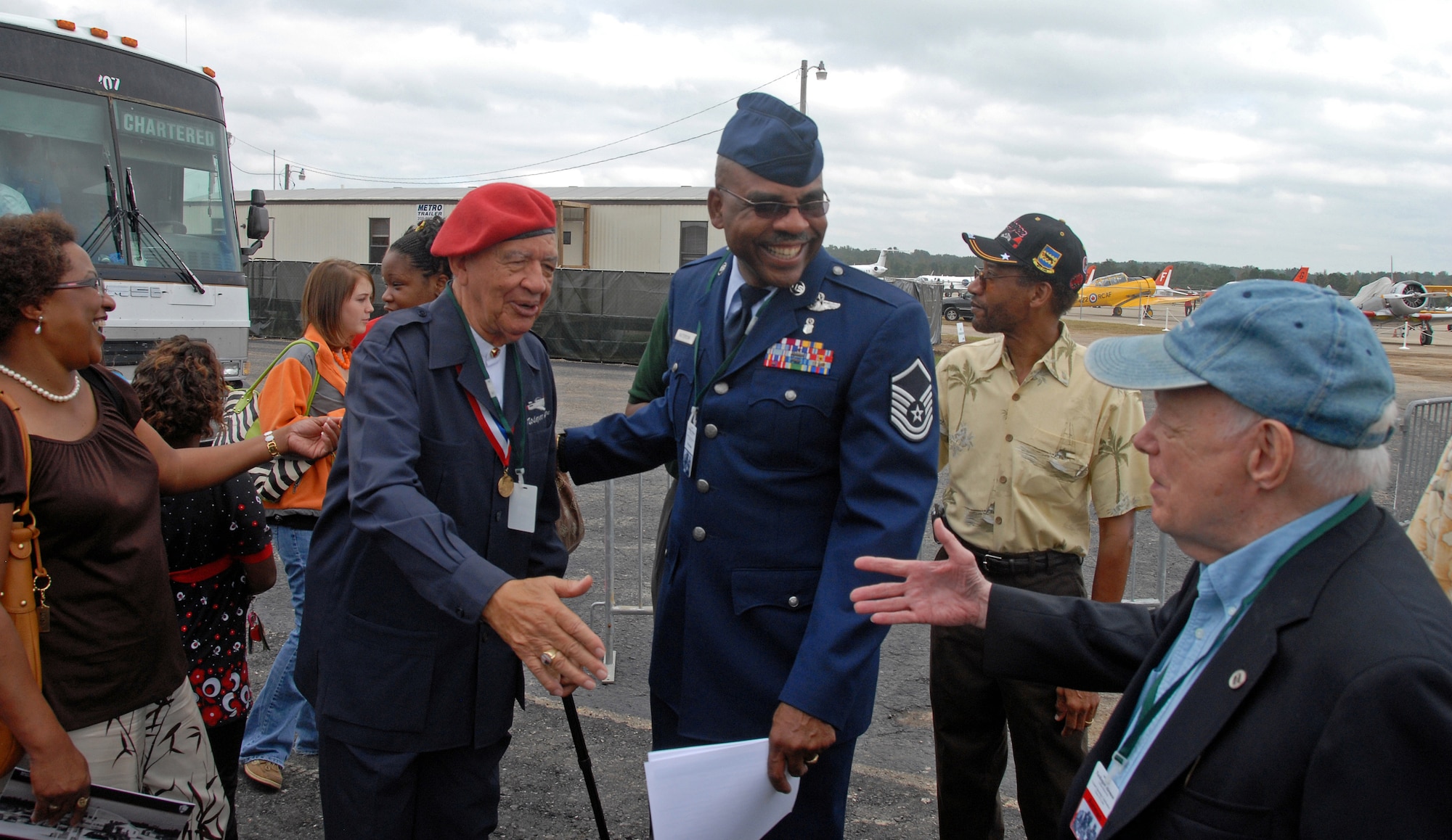 A Tuskegee Airman attending the grand opening activities exchanges pleasantries with the 908th Airlift Wing's Master Sgt. Ronnie Patterson and a well-wisher at grand opening activities for the Tuskegee Airmen National Historic Site at Moton Field, Tuskegee, Ala. Oct. 10. (U.S. Air Force Photo by Lt. Col. Jerry Lobb)         