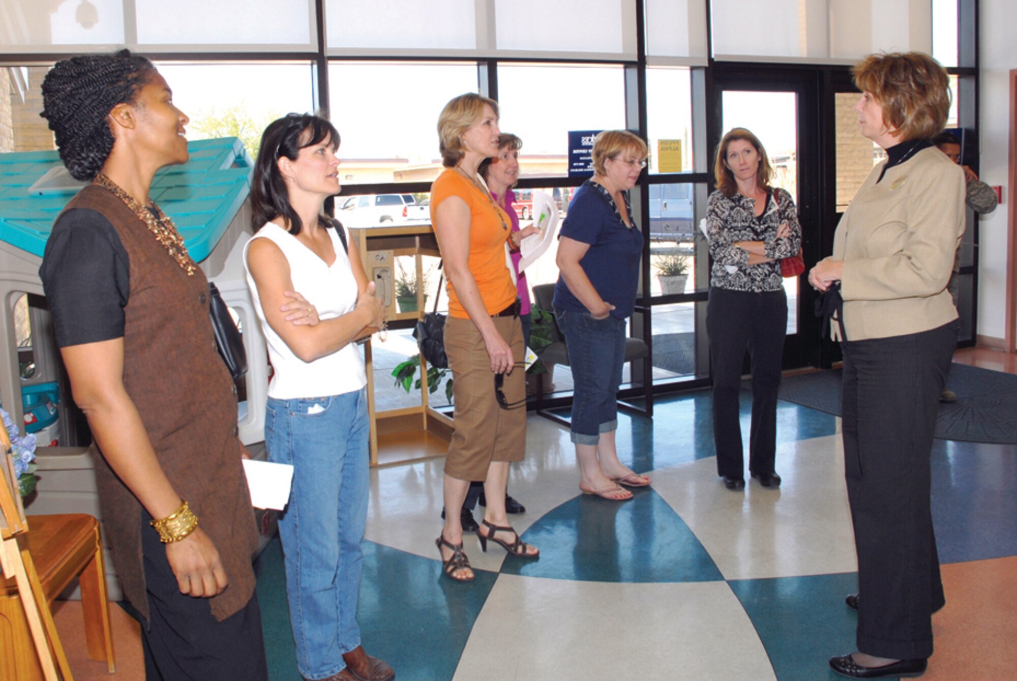 Sandy Neubauer and other wives of Luke Air Force Base leadership got the opportunity to tour the services side of the base. Here, Cheryl Cotton of the youth center explains the various activities offered by the youth center to the group of spouses during their tour Oct. 15. (U.S. Air Force Photo/Deborah Silliman-Wolfe.)