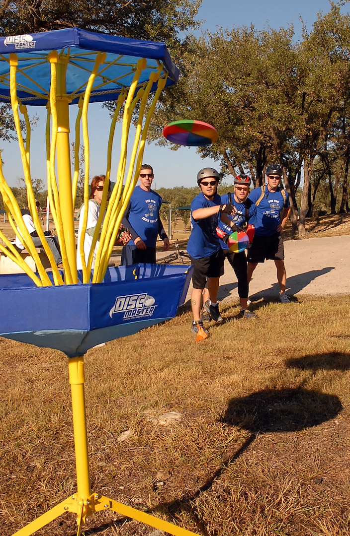 Brian Broyles, James Sayres, Michael Humphrey and Tim Okkerse, ?Texas Port Dawgs? relay team, make a toss for the disc golf portion of the Rambler 120. Participants from four U.S. Air Force Bases competed in the triathlon held each year at Canyon Lake. (U.S. Air Force photo by Staff Sgt. Tim Bazar)