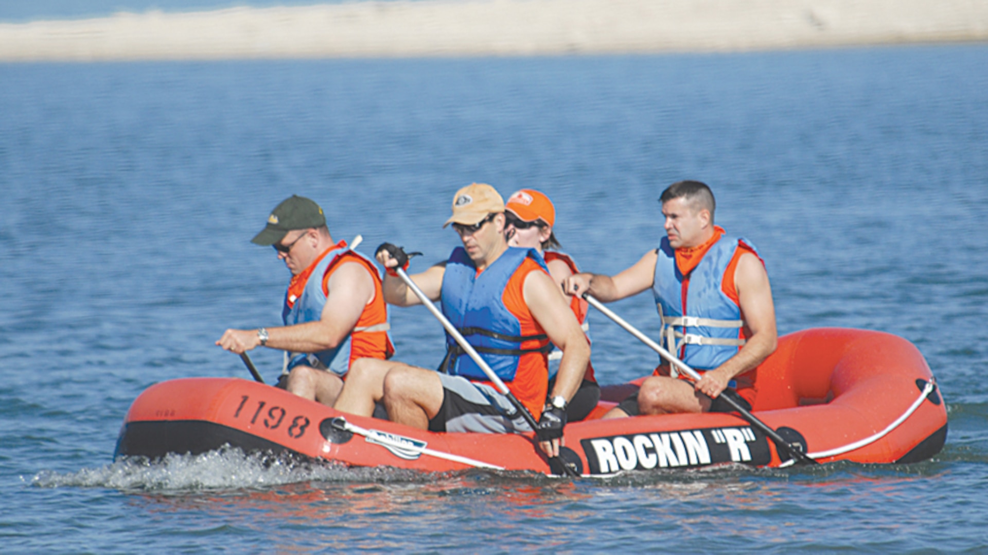 Members of the ?Orange Crush? relay team, Patrick Grolemund, David Dentino, Jessica Woods and Joseph May, row towards shore as they complete the rafting portion of the Rambler 120. Orange Crush finished with the bronze medal in the Co-ed Relay division. Participants from four U.S. Air Force Bases competed in the triathlon held each year at Canyon Lake. (U.S. Air Force photo by Steve White)