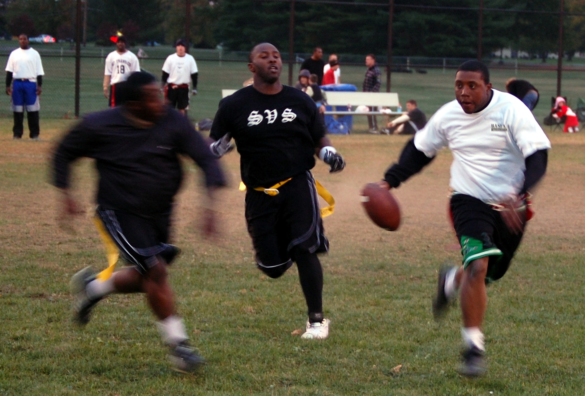 Quarterback Cecil Evans from the U.S. Air Force Expeditionary Center's "Screaming Eagles" intramural flag football team scrambles away from defenders during football action against the 305th Services Squadron on McGuire Air Force Base, N.J., Oct. 22, 2008.  USAF EC defeated McGuire Services 12-6 to improve to 9-3 on the season.  (U.S. Air Force Photo/Tech. Sgt. Scott T. Sturkol)