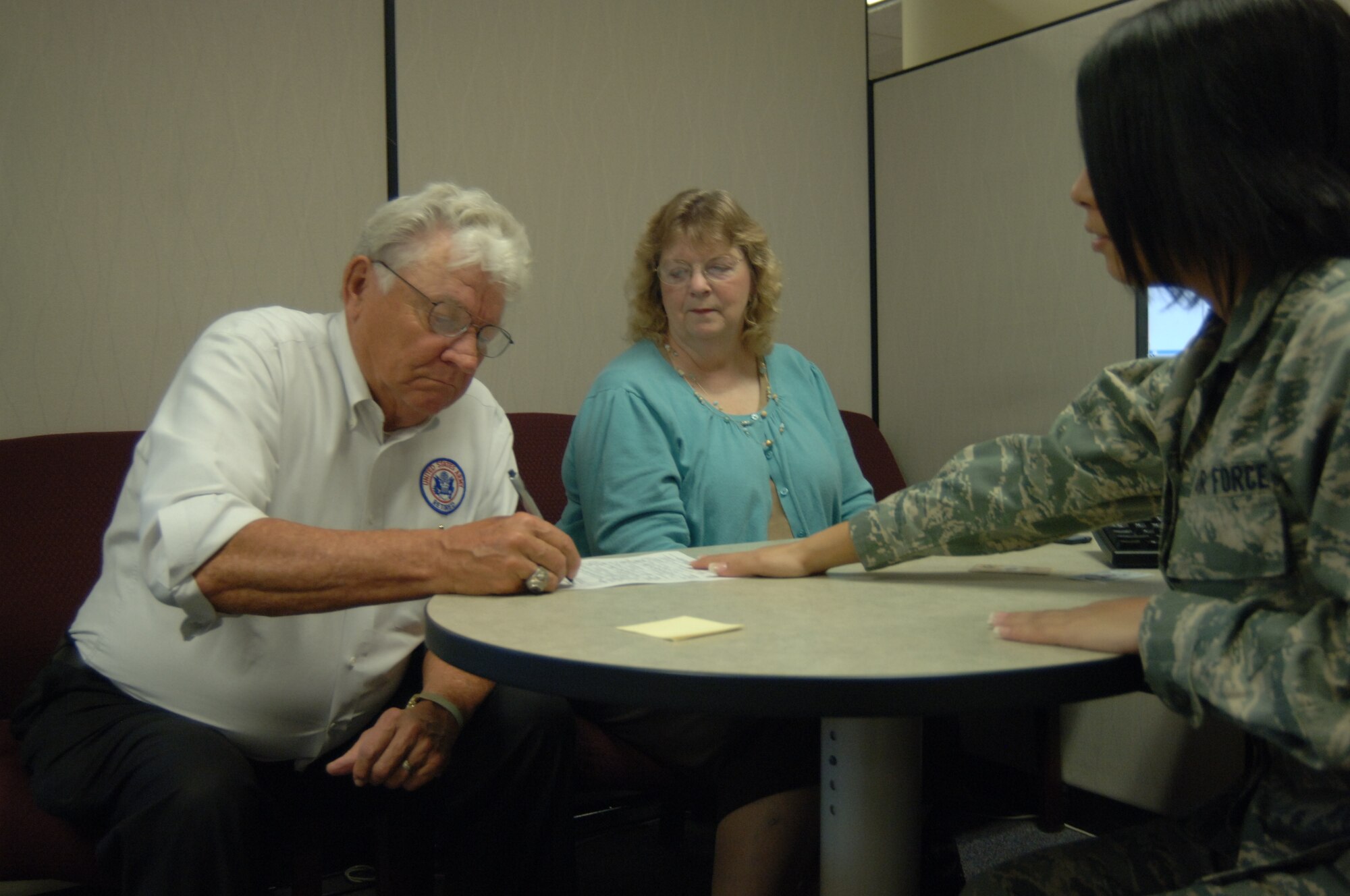Airman Basic Chrisstie Carmona, 55th Force Support Squadron personnelist, assists retired Army Master Sgt. Ralph Johnson and his wife Betty Johnson with updating their military identification cards during the annual Retiree Appreciation Day Oct. 19. Services offered at this annual event include briefings and booths from the retiree affairs office, the airman and family readiness center, various veterans’ affairs offices and TRICARE among others as well as base tours and flu shots from the 55th Medical Group. (U.S. Air Force Photo By Tech. Sgt. Rhonda Moraski) 