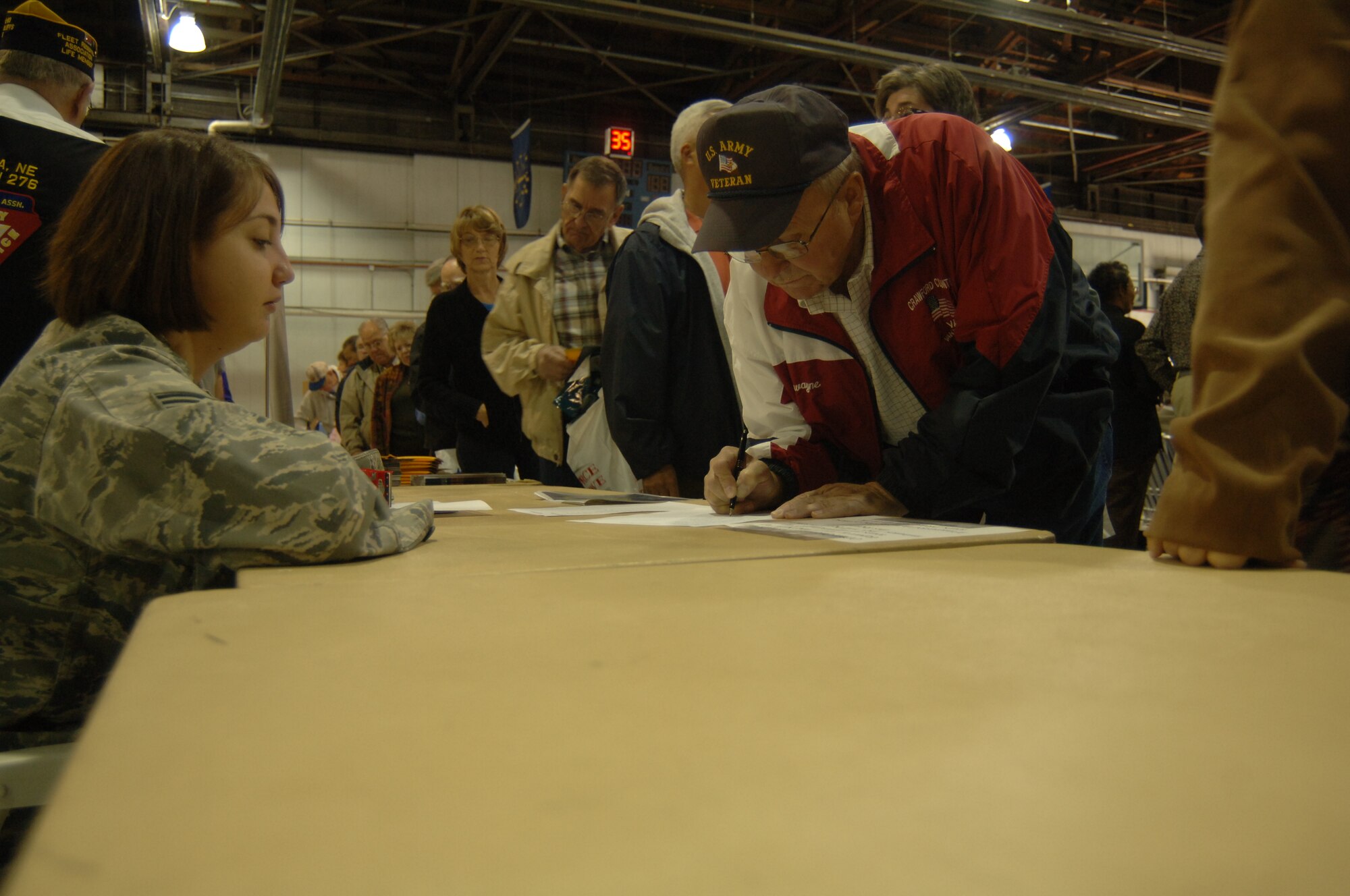 Senior Airman Amanda Dick, 55th Wing Public Affairs community relations journeyman, assists retired Army Staff Sgt. Lawayne Gronau sign up for one of the several base tours offered at the annual Retiree Appreciation Day Oct. 19 at the field house. Services offered at this annual event include briefings and booths from the retiree affairs office, the airman and family readiness center, various veterans’ affairs offices and TRICARE among others as well as base tours and flu shots from the 55th Medical Group. (U.S. Air Force Photo By Tech. Sgt. Rhonda Moraski)