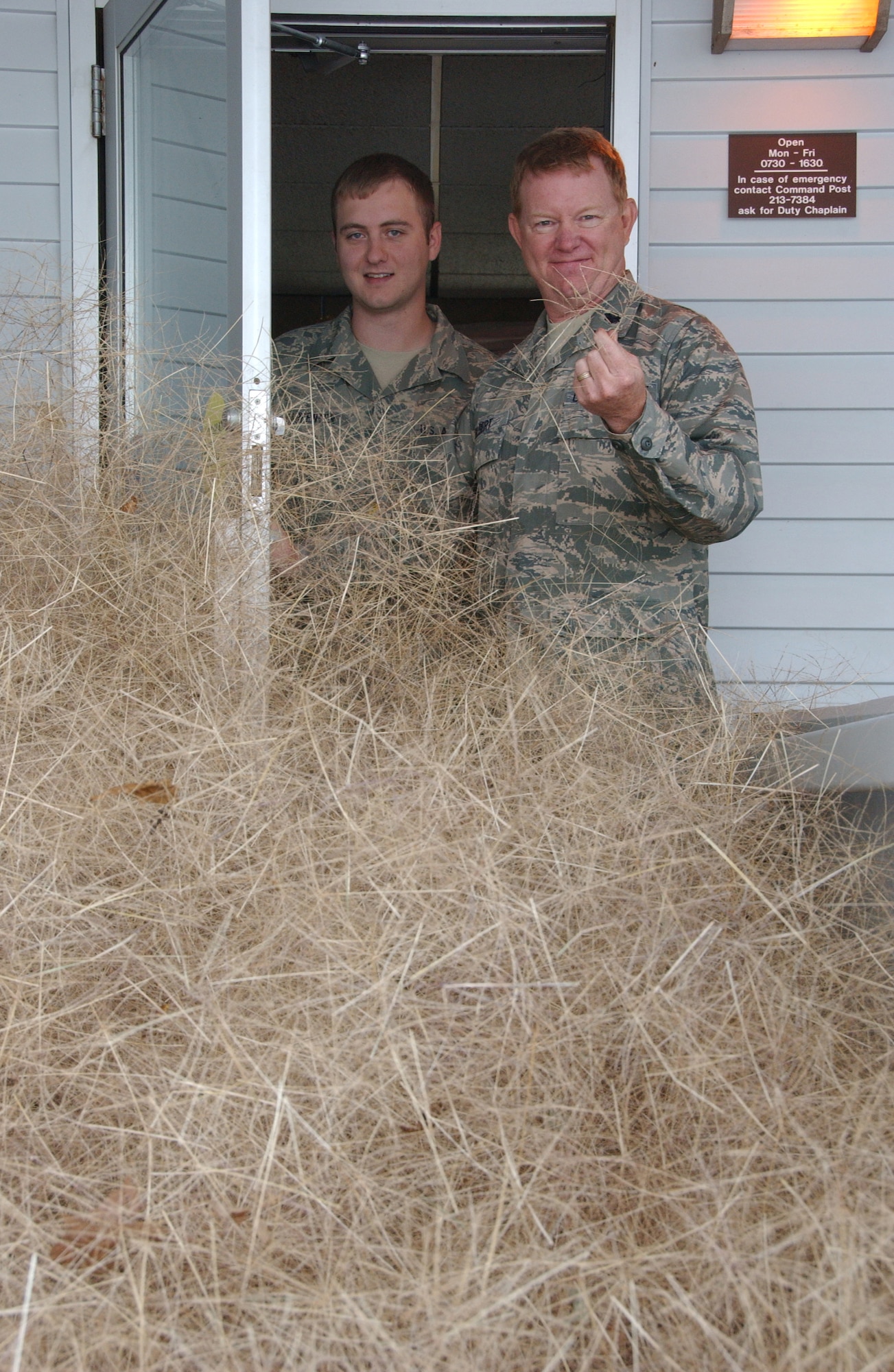 Staff Sgt. Jonathon Carpenter (left) and Chaplain (Lt. Col.) Michael Gilbert marvel at the five-foot drift of tumbleweeds that gathered in the alcove of the Vance chapel. Tumbleweeds are a common site in northwest Oklahoma in autumn. (U.S. Air Force photo by Staff Sgt. Brian Hill)