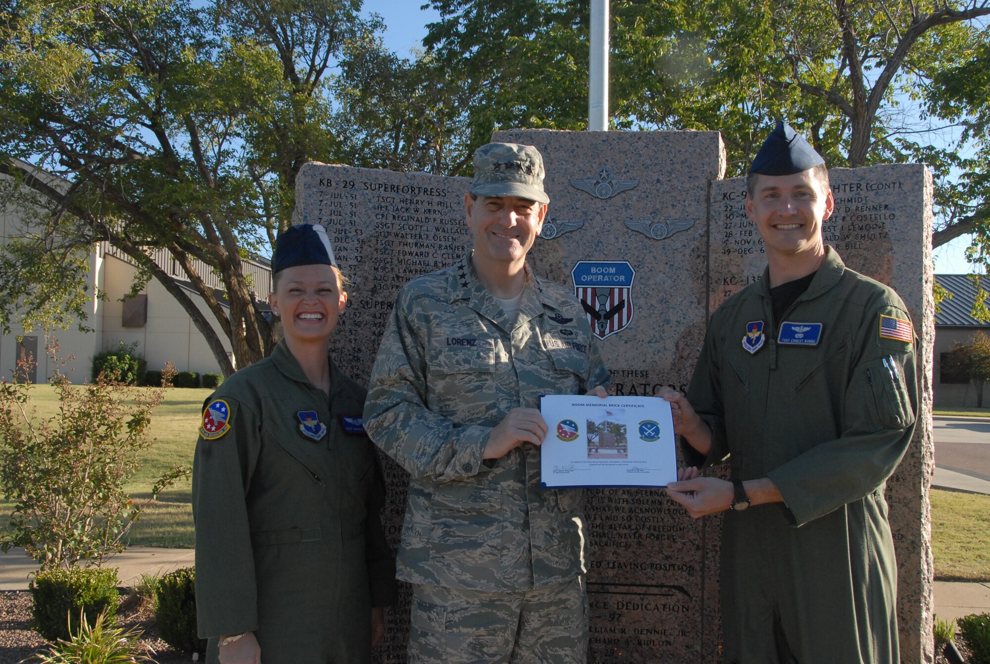 ALTUS AIR FORCE BASE, Okla. – Staff Sgt. Shonna Calisi, 54th Air Refueling Squadron, (L), and Master Sgt. Ernest Burns, 55th ARS boom operator instructors presented Gen. Stephen R. Lorenz, Air Education and training commander a certificate and engraved brick in his honor to be placed at the Altus AFB Boom Operators Memorial Oct. 7.  General Lorenz was a prior KC-135 pilot.  The Altus Boom Operators Association felt it was fitting to dedicate an engraved brick for his continued support of the tanker and boom operators.  The memorial was dedicated in 2005 to honor 117 Boom Operators who gave the ultimate sacrifice while performing their duties aboard aircraft.  (U.S. Air Force photo/Aiman 1st Class Cherice I. Bryant.)