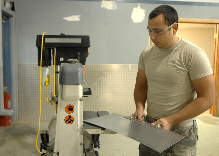 Airman 1st Class Joseph Williams, 4th Equipment Maintenance Squadron, uses a belt sander to round the edges of a piece of aluminum in the sheet metal shop on Seymour Johnson Air Force Base, N.C., Oct. 21, 2008. Sheet metal Airmen attend a four month technical school in Pensacola, Fla., to learn everything from general shop practices to aircraft sanding, priming and painting. (U.S. Air Force photo by Airman 1st Class Makenzie Lang)