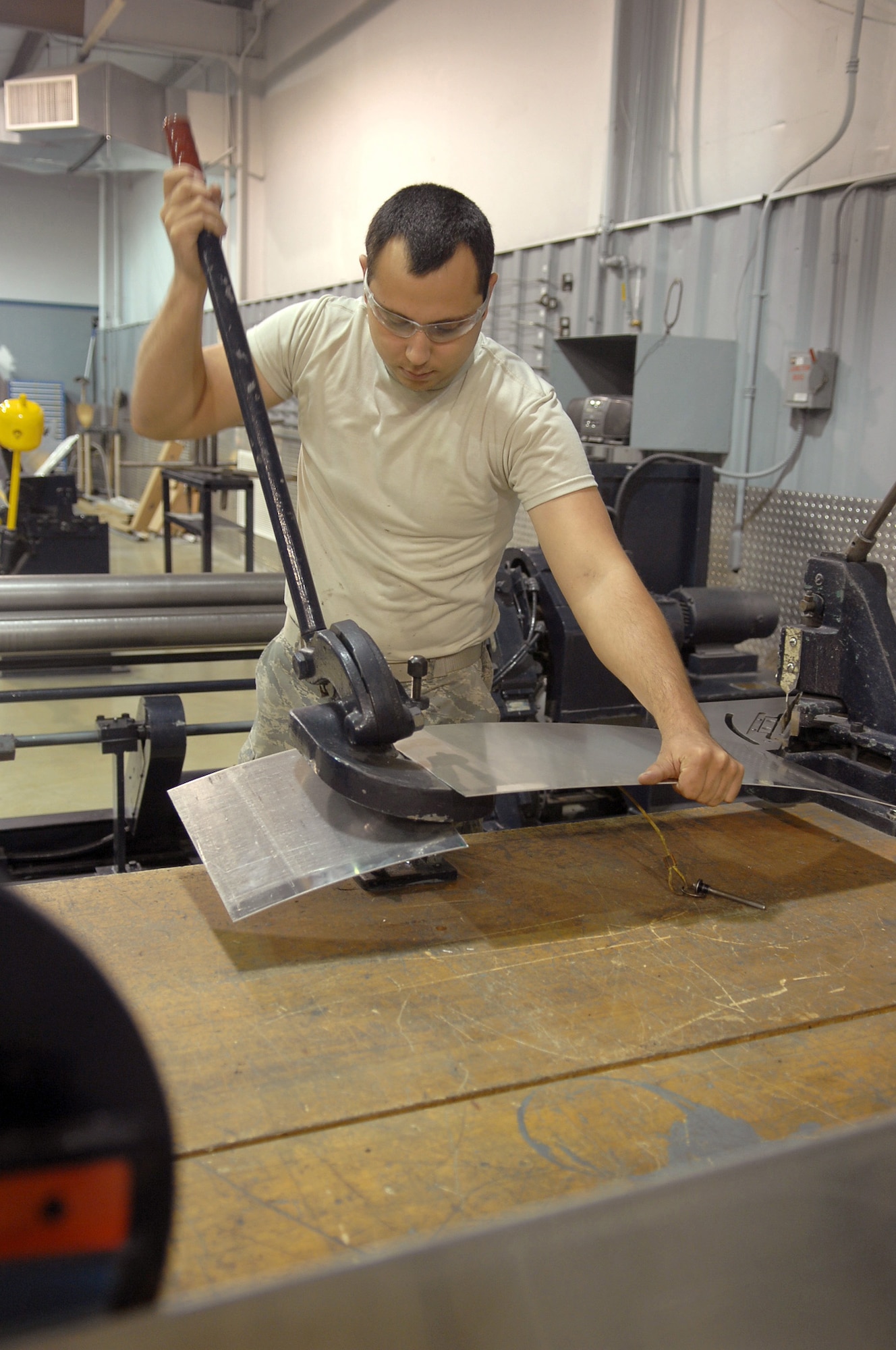 Airman 1st Class Joseph Williams, 4 Equipment Maintenance Squadron, uses a Throatless Shear Cutter to cut a piece of aluminum in the Sheet Metal shop on Seymour Johnson Air Force Base, N.C., Oct. 21, 2008. A1C Williams was preparing to use the aluminum as a fuselage patch on an F-15 Eagle. (U.S. Air Force photo by Airman 1st Class Makenzie Lang)