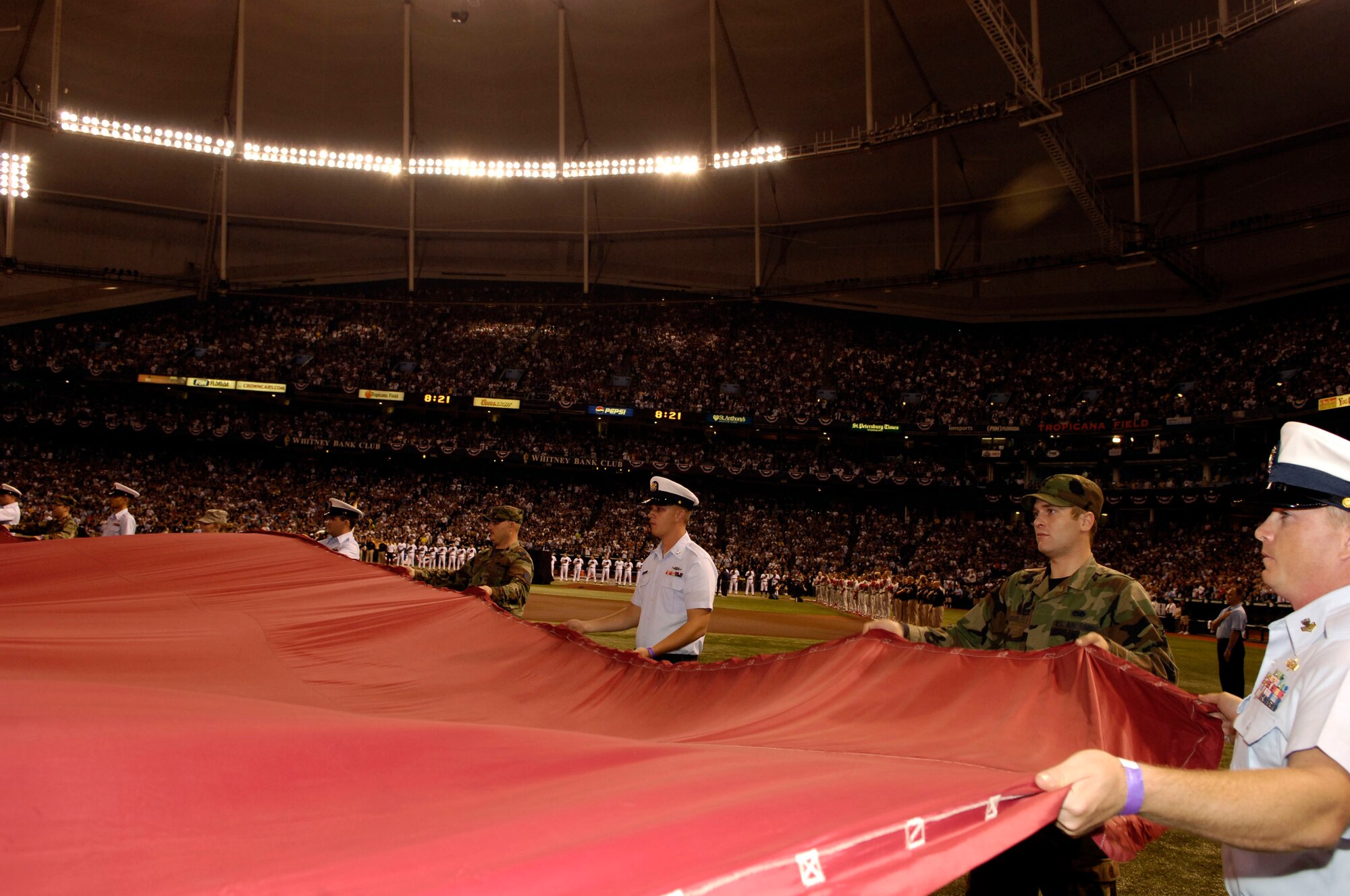 Members of the 6th Air Mobility Wing along with members of the U.S. Coast Guard assigned to sector St. Petersburg, Fla., hold the American Flag during the playing of the National Anthem in the first game of the World Series Oct. 22, where the Philadelphia Phillies took on the Tampa Bay Rays. (U.S. Air Force Photo by Senior Airman Stephenie Wade)