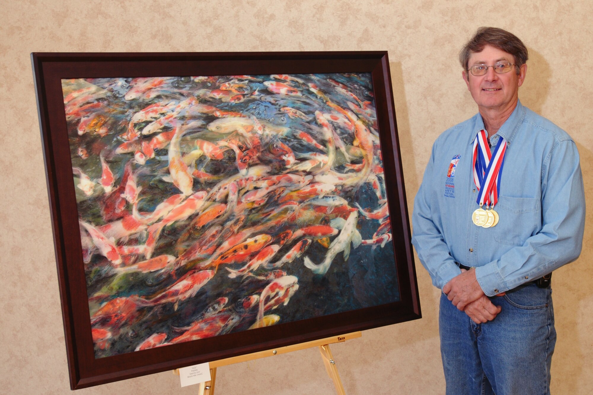 Retired Lt. Col. Dennis Linn poses with his painting, "Koi," Oct. 22 in Riverside, Calif. Colonel Linn is a veteran of Operation Enduring Freedom who suffers from cardiovascular disease. He is one of more than 120 disabled veterans participating in the National Veterans Creative Arts Festival. (Department of Veterans Affairs photo/Gene Davies) 
