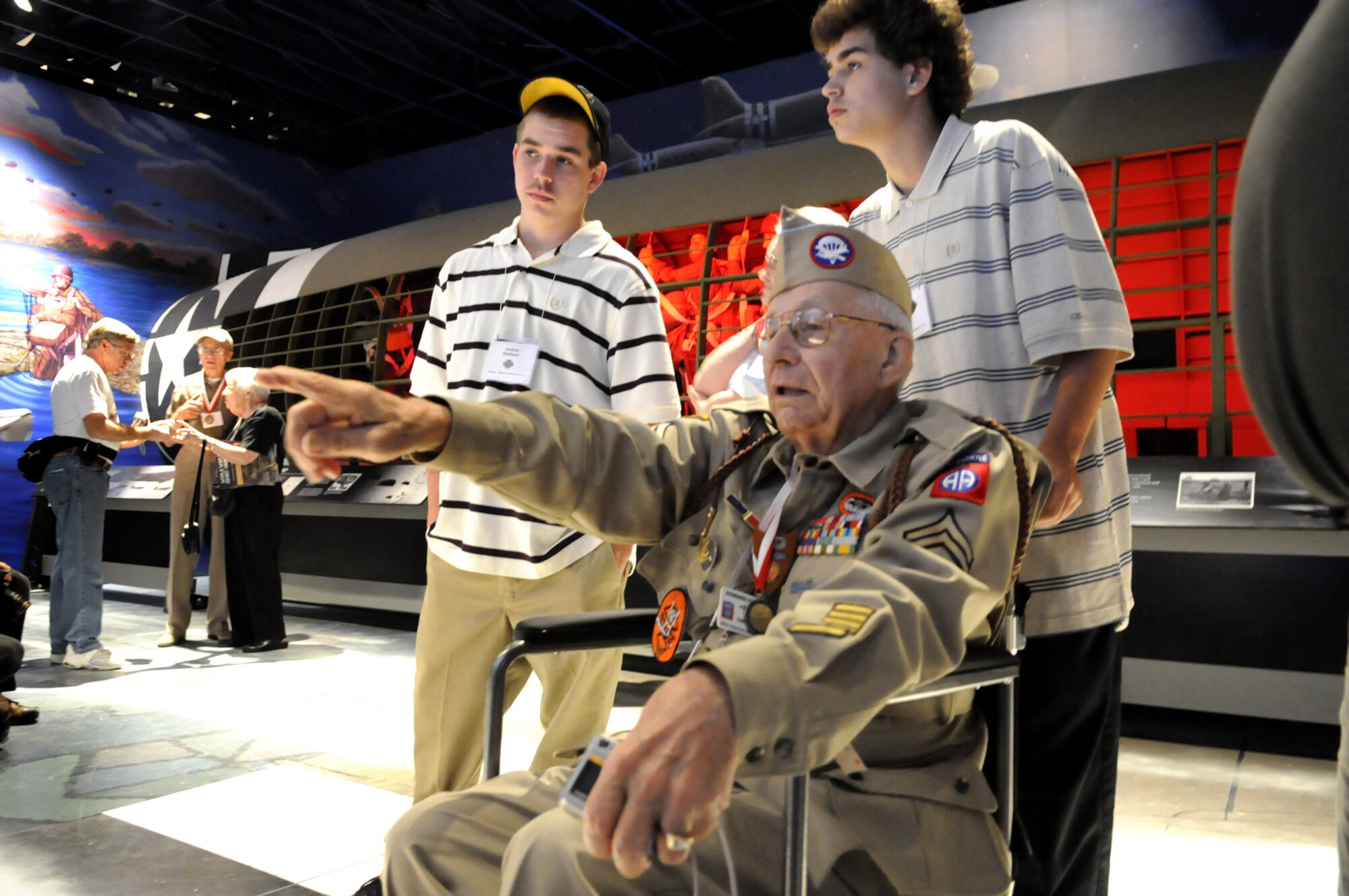 Howard Huebner, tells his grandsons Josh and Jeremy, about some of the memories he recalls while touring the new WWII exhibit. U. S. Air Force photo by Sue Sapp