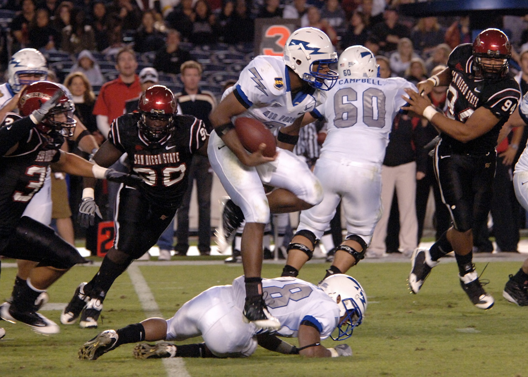 Freshman quarterback Tim Jefferson looks for running room as he hurdles his blocker, tailback Kyle Lumpkin, during an option play.  In his first start, Jefferson ran 12 times for 55 yards and a touchdown while leading the Falcons offense to 401 yards on the ground and 473 yards of total offense in a 35-10 win over San Diego State University.  (U.S. Air Force photo/Staff Sgt. Steve Grever)