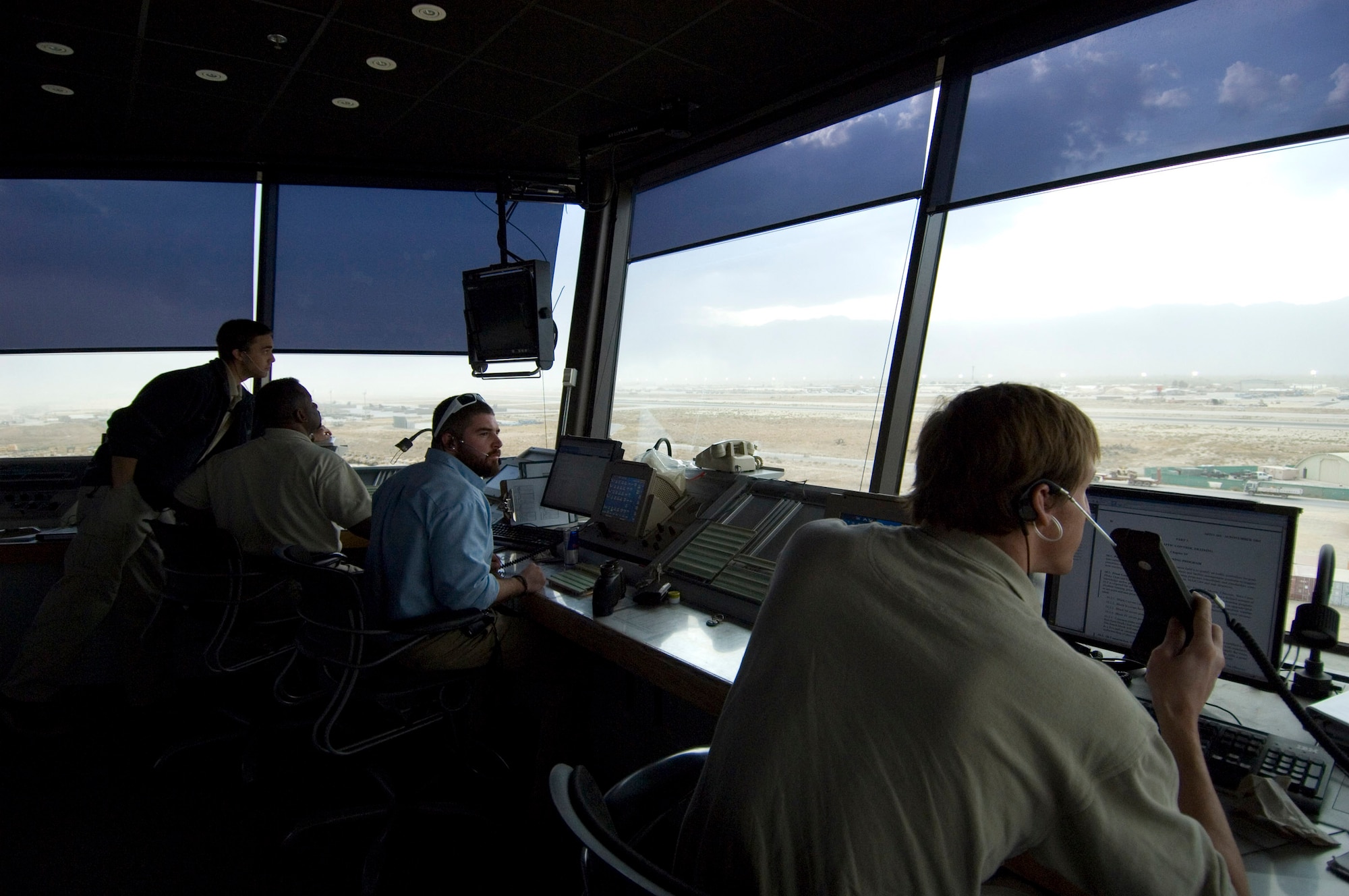 Department of Defense contractors monitor the airfield from the air traffic control tower at Bagram Airfield, Afghanistan, Oct. 21. Many of the airfield operations functions, such as air traffic control and airfield management, are done through contracts and monitored by the 455th Expeditionary Operations Support Squadron Airfield Operations Flight. (U.S. Air Force photo by Staff Sgt. Rachel Martinez/released)