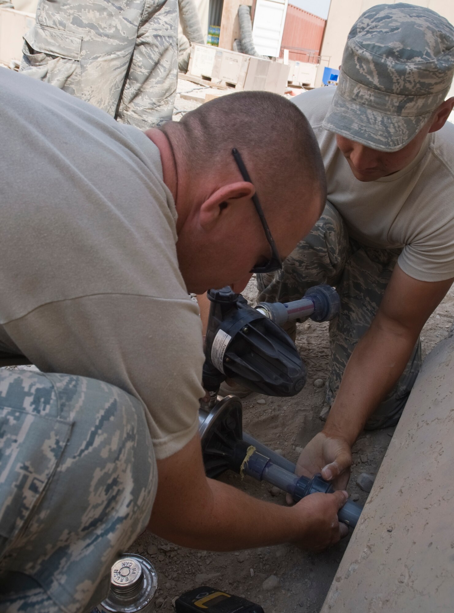 ALI BASE, Iraq -- Staff Sgts. Dustin Bray and Steven Javinar, 407th Expeditionary Civil Engineer Squadron, prepare to attach a water pump to the water tank Oct. 22, 2008. The water tank will provide running water for a snack bar. People stationed here now have another Army and Air Force Exchange Service store to purchase necessities. Bray and Javinar are deployed from F.E. Warren Air Force Base, Wyo. (U.S. Air Force photo/Senior Airman Christopher Griffin) 
