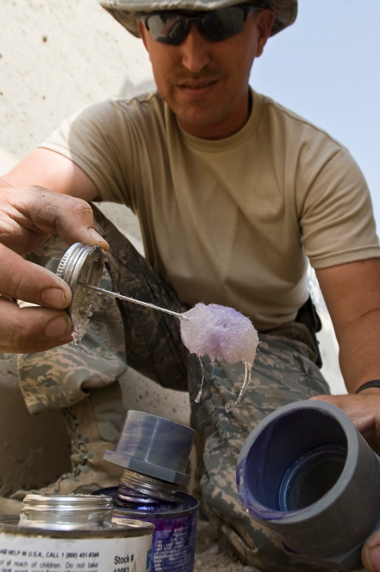 ALI BASE, Iraq -- Staff Sgt. Dustin Bray, 407th Expeditionary Civil Engineer Squadron utilities system craftsman, applies glue to a water tank adapter Oct. 22, 2008. The water tank will provide running water for a snack bar. People stationed here now have another Army and Air Force Exchange Service store to purchase necessities. Bray is deployed from F.E. Warren Air Force Base, Wyo. (U.S. Air Force photo/Senior Airman Christopher Griffin) 