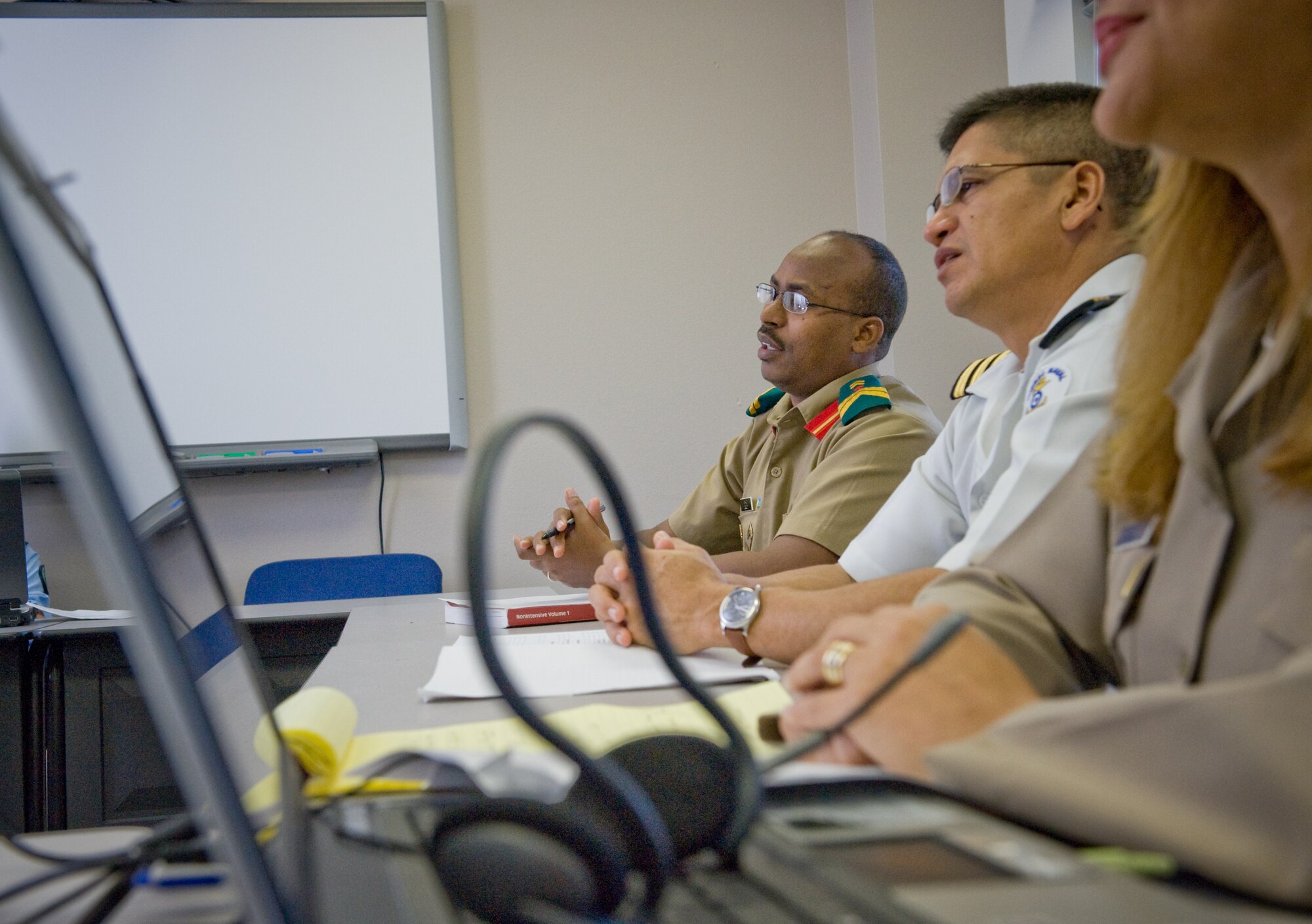 Laptop computers and headsets proliferate the classroom where Djibouti army Sgt. Saad Moussa Bouraleh (left) El Salvador navy Cmdr. Cesar Mejia Polanco discuss some intricacies of native languages during the American English Language Instructor Course Oct. 22 at the Defense Language Institute at Lackland Air Force Base, Texas.  (U.S. Air Force photo/Lance Cheung)