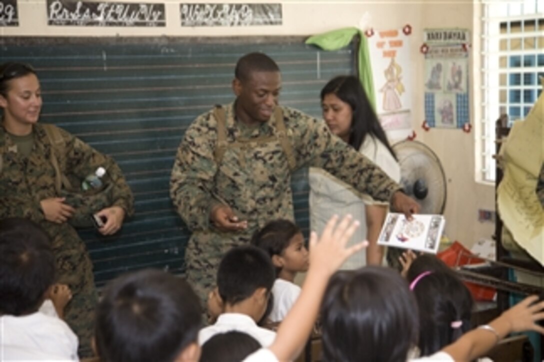 U.S. Marine Corps Sgt. Carlos Jones passes out notebooks to students during a community relations event at Marcos Elementary School in Mabalacat, Philippines, on Oct. 20, 2008.  The event is being conducted by U.S. Marines and sailors from the 3rd Marine Expeditionary Brigade and Philippine airmen as part of Talon Vision and Amphibious Landing Exercise 2009.  The annual bilateral training exercises are conducted between the Armed Forces of the Philippines and the U.S. military to enhance military interoperability and improve communities through humanitarian assistance and civil action projects.  

