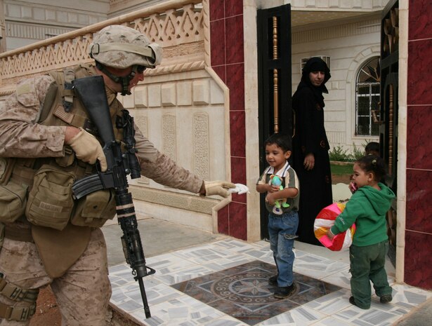 During a routine security patrol in the town of Rutbah, Iraq, Oct. 23, Cpl. Joseph Shutta, an infantryman with Weapons Company, 2nd Battalion, 25th Marine Regiment, Regimental Combat Team 5, gives stuffed animals to children outside their family home.  The stuffed animals were sent to the Marines at the expense of patriotic organizations in the United States under the umbrella of America Supports You, a Department of Defense organization created several years ago to consolidate grass-roots 501(c) non-profit organizations wishing to support the troops in the Global War on Terror. ::r::::n::