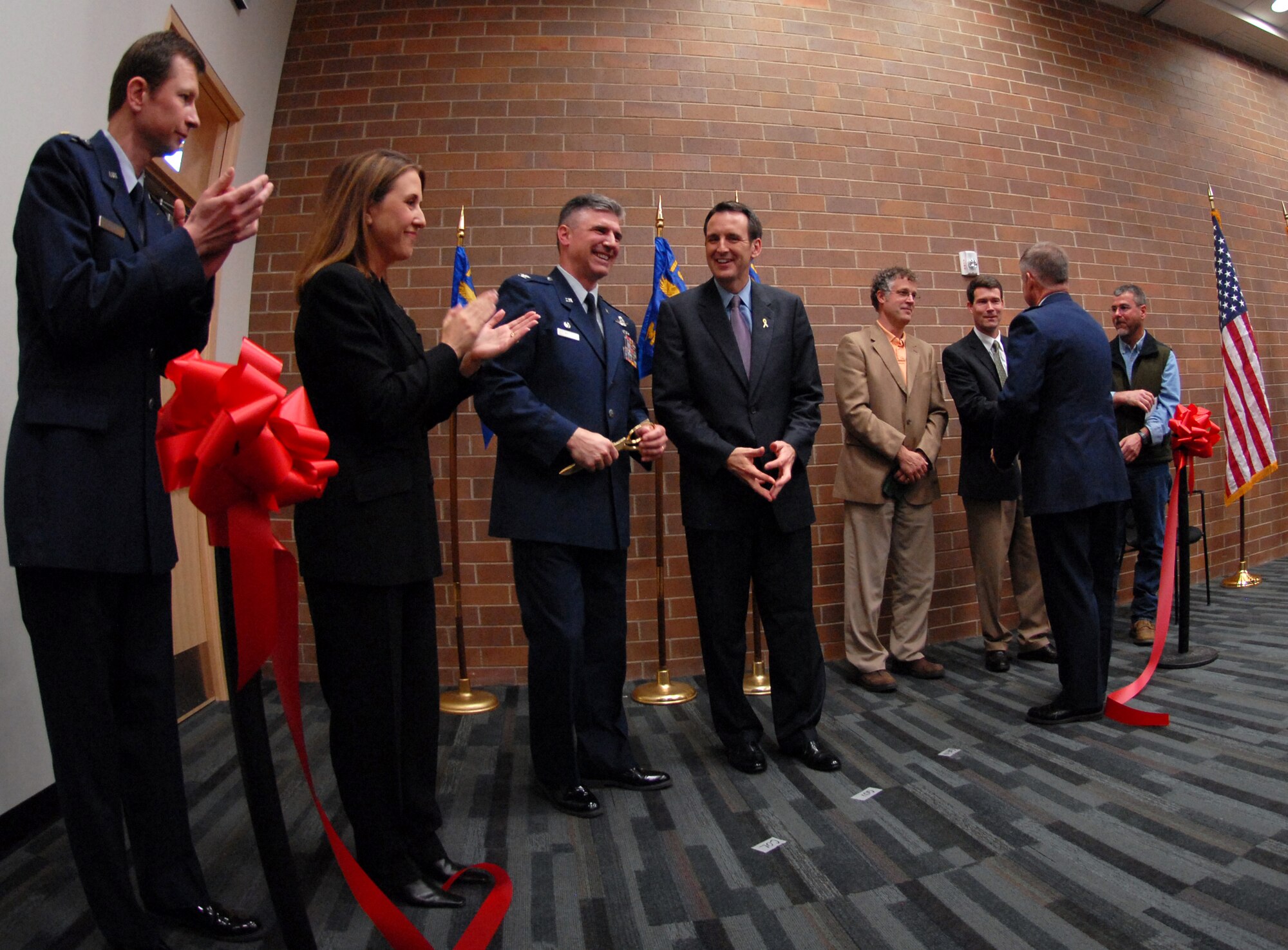 The official red ribbon drops severed to the ground, a testament to the meticulous planning and construction that has occurred to make the new composite maintenance building at the 133rd Airlift Wing in Saint Paul a facility to be proud of. (From left to right: Team designers Maj. Michael Piontek and Ms. Barbara O'Brien, 133rd Airlift Wing Commander Col. Greg Haase, Gov. Tim Pawlenty, and  the Assistant Adjutant General of Air, Brig. Gen. Timothy Cossalter.)