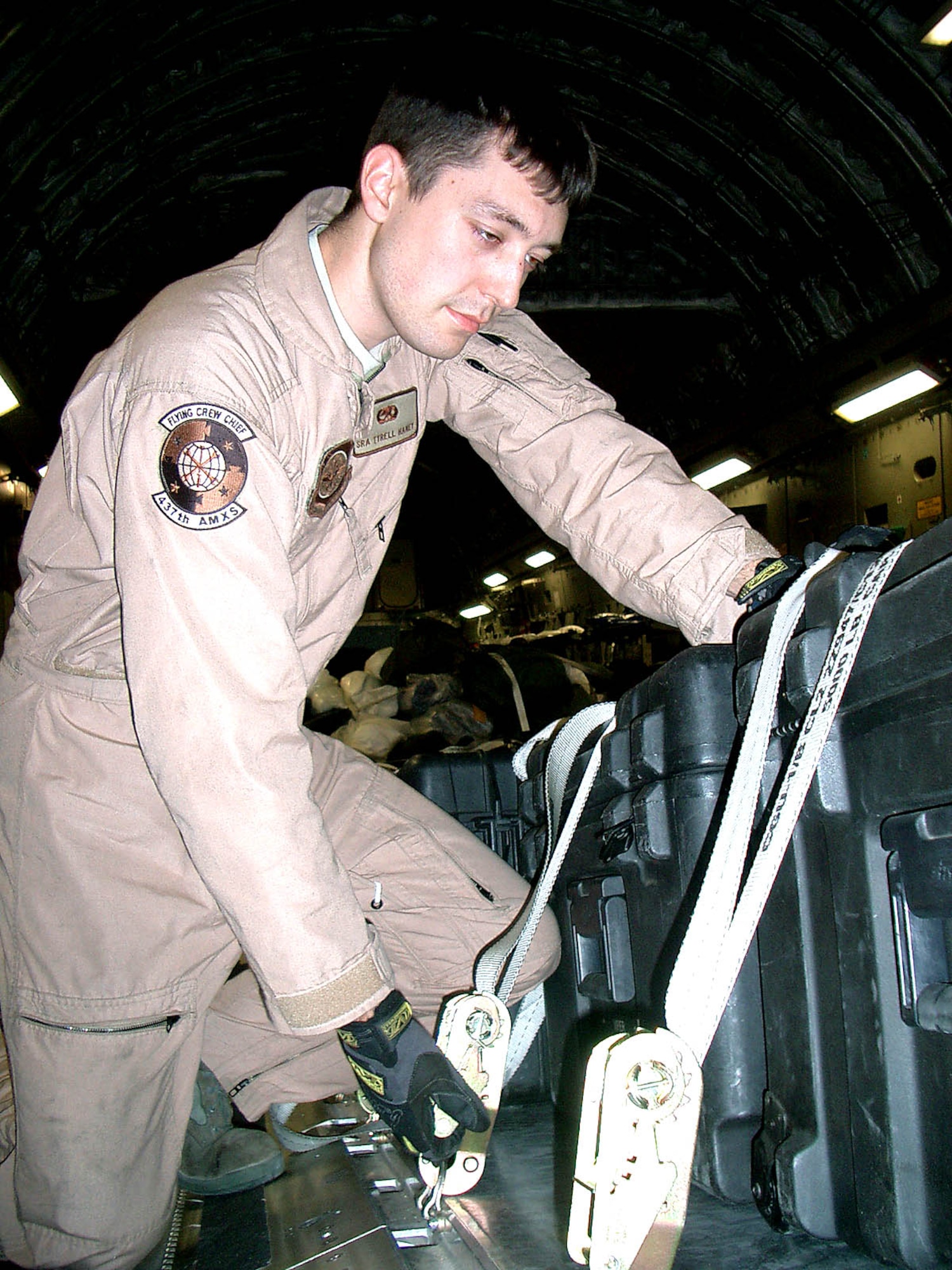Senior Airman Tyrell Haney, a 437th Aircraft Maintenance Squadron crew chief from Charleston Air Force Base, S.C. secures a pallet Oct. 23 aboard a C-17 Globemaster III transporting Air Force Chief of Staff Gen. Norton A. Schwartz and Chief Master Sgt. of the Air Force Rodney J. McKinley.  The Air Force leaders were on a visit to various locations in the U.S. Central Command area of operations, including bases in Iraq, Afghanistan and the Horn of Africa. Airman Haney reenlisted in a ceremony during the flight. (U.S. Air Force photo/Senior Master Sgt. Sean E. Cobb)