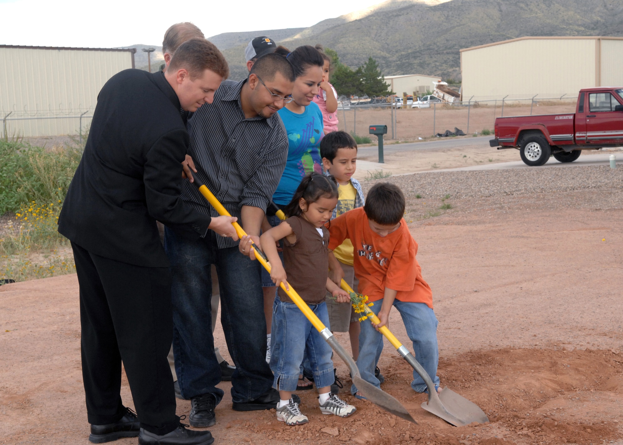 Chaplain Matt Glaros, 49th Fighter Wing Chapel, helps the Duran family during the groundbreaking ceremony, October 12,  at the building site of a new Habitat for Humanity home in Alamogordo, N.M. Chaplain Glaros attended the ceremony on  26th street to give an invocation for the soon-to-be homeowners . (U.S. Air Force photo/Airman 1st Class Veronica Salgado)