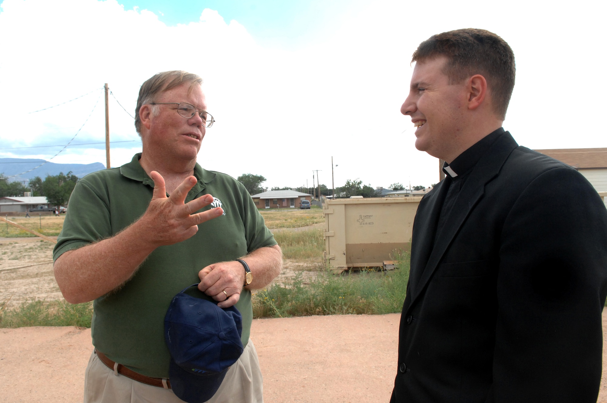 Mr. Norman Daviess, board president of the Otero County Habitat for Humanity organization, speaks with Chaplain Matthew Glaros during the groundbreaking ceremony in Alamogordo, N.M., October 12. Mr. Daviess explains how families with financial difficulty have the opportunity to build a house with the help of Habitat for Humanity volunteers. (U.S. Air Force photo/Airman Veronica Salgado)