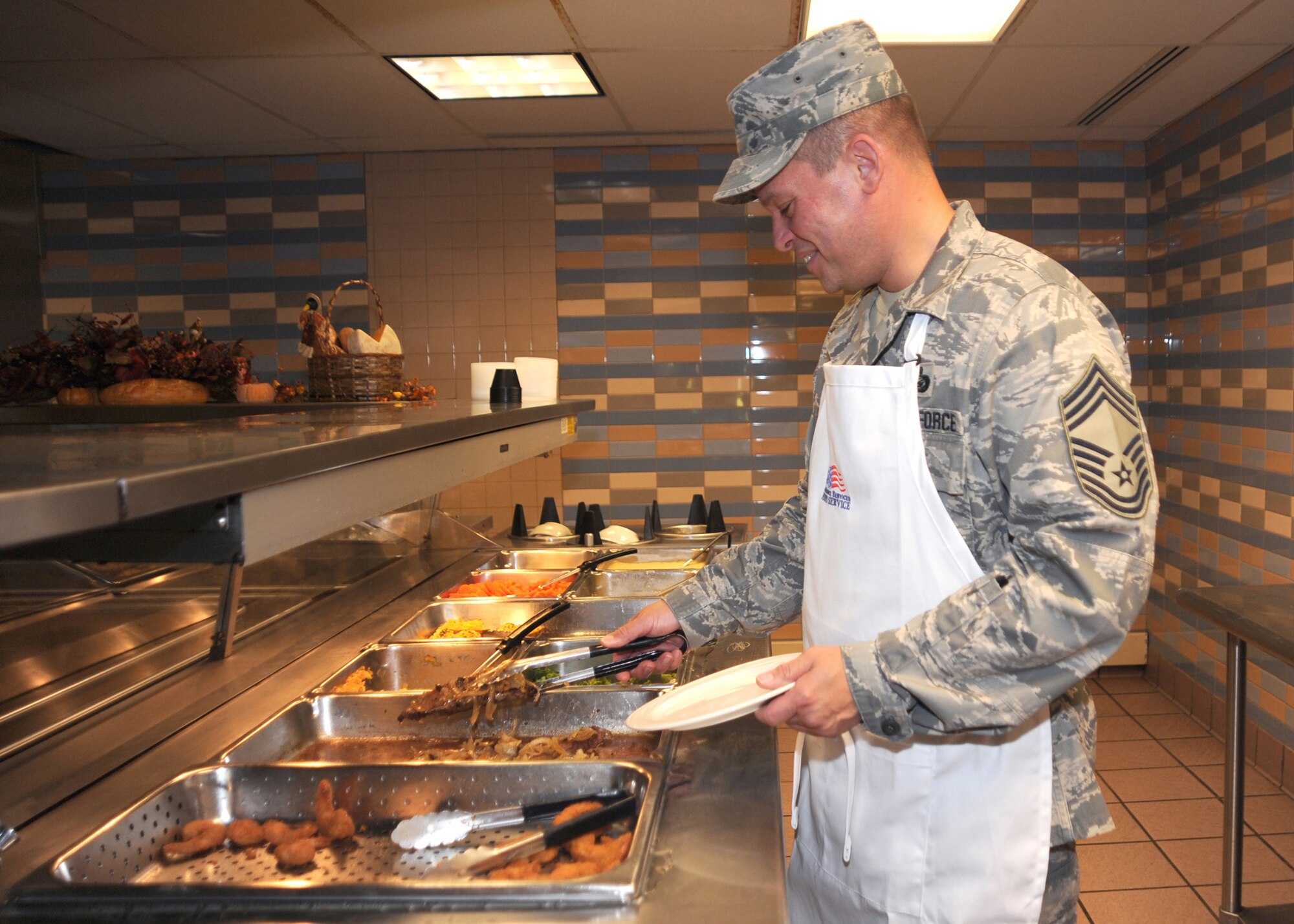 CANNON AIR FORCE BASE N.M. -- Chief Master Sgt. Hector Baez, 27th Special Operations Mission Support Group, serves steak at the Quarterly Birthday Meal to Senior Airmen and below Oct 23 at the Pecos Trail Dining Facility. Other wing leadership volunteered to serve Airmen at their tables making sure they had a comfortable dining experience. (U.S. Air Force photo by Airman Maynelinne De La Cruz)   