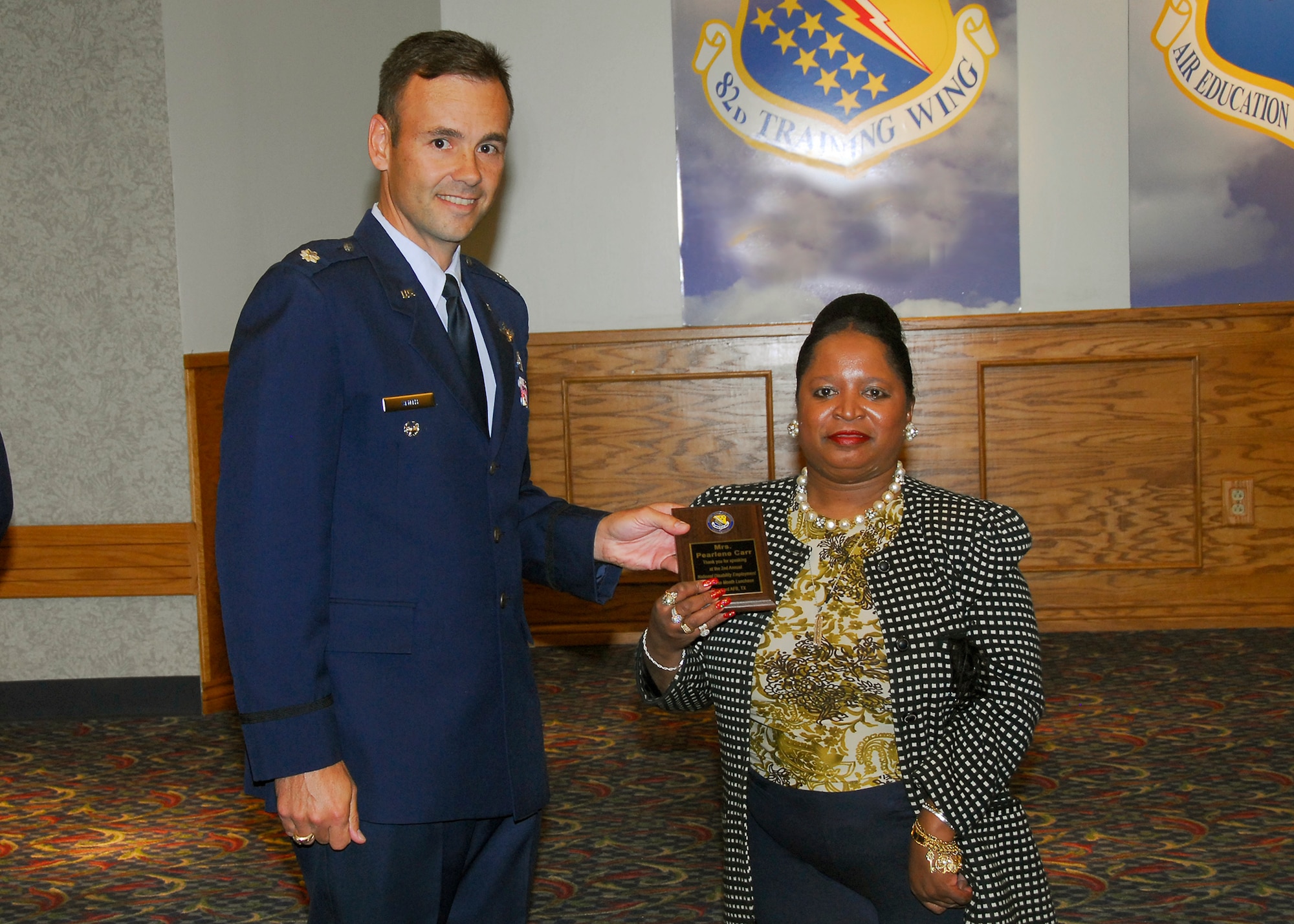 Lt. Col. Porter Smith, 82nd Mission Support Group Deputy Commander, presents Pearlene Carr, 82nd Contracting Squadron, a plaque for speaking at the National Disability Employment Awareness Month luncheon Oct. 23 at the Sheppard Club. (U.S. Air Force photo/Harry Tonemah)