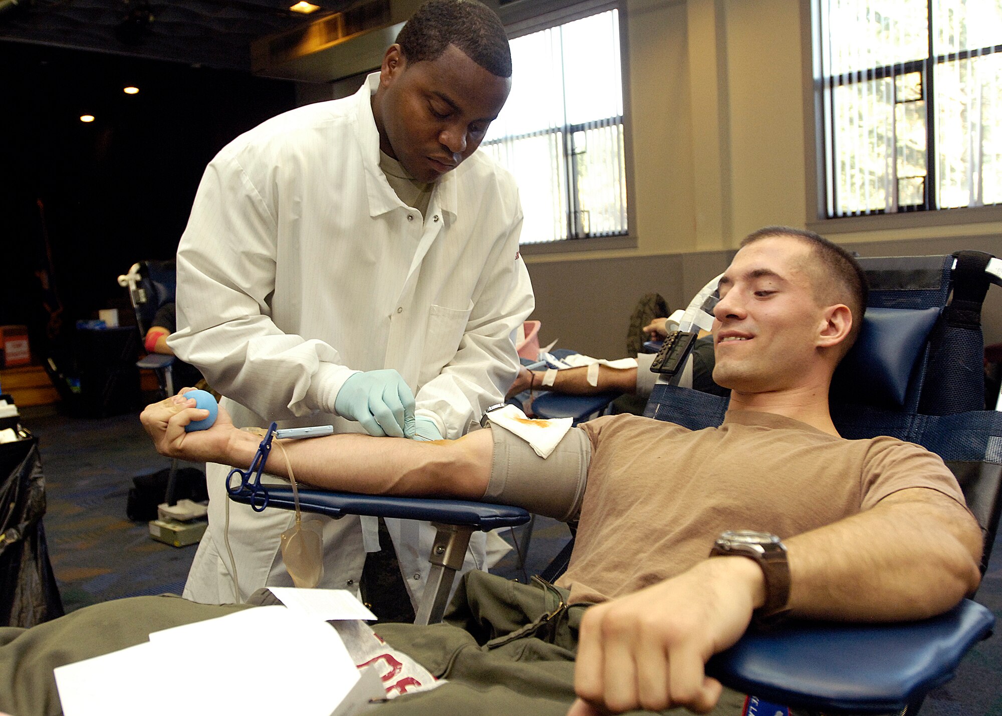 FAIRCHILD AIR FORCE BASE, Wash. – Senior Airman Luke Lawson, 93rd Air Refueling Squadron boom operator, anxiously grins as a prodding needle is inserted into his arm at the Deel Community Center Oct. 23. Airman Lawson was one of many at Fairchild to offer his blood to troops currently deployed in support of Operations Enduring  and Iraqi Freedom. (U.S. Air Force photo / Senior Airman Eunique Stevens)
