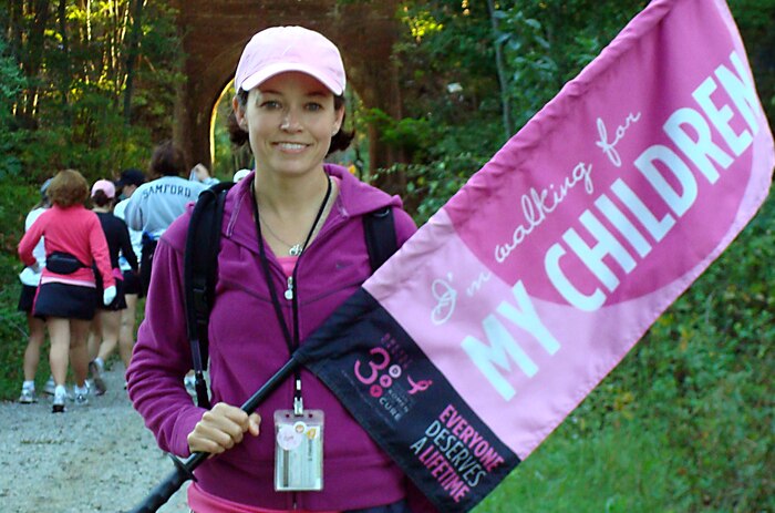 Maj. Sara Huiss poses with a flag proclaiming why she walked during the Breast Cancer 3-Day in the Washington, D.C., area Oct. 4. She, along with thousands of other men and women, walked 60 miles in three days to raise money for the Susan G. Komen for the Cure National Philanthropic Trust. Major Huiss is the 437th Maintenance Squadron commander. (Courtesy photo)