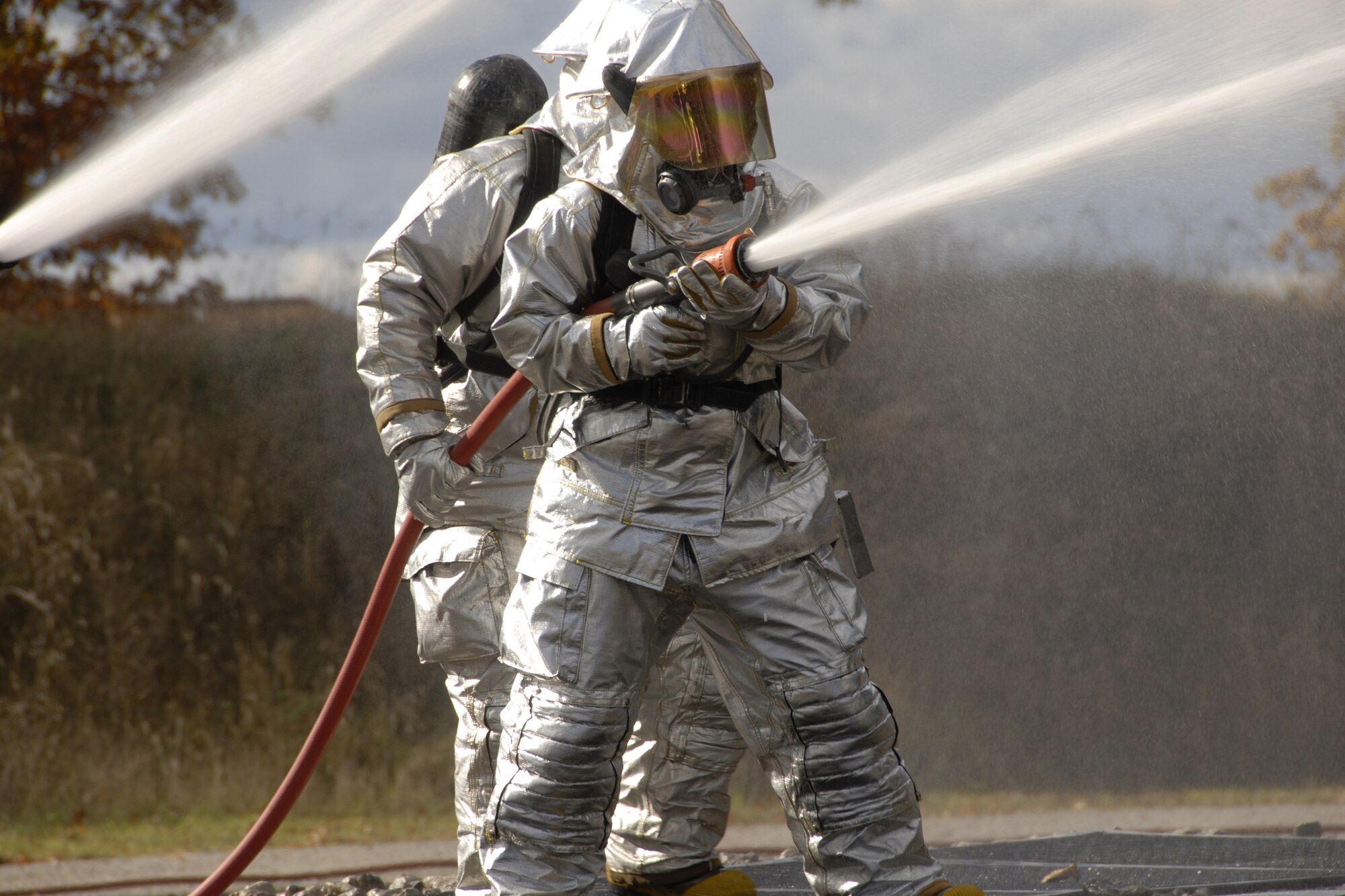 Staff Sgt. Keith Vasicek and Airman 1st Class Tony Pastrone battle a controlled fire during an aircraft crash site drill Oct. 18 at CRTC Training Base Alpena Mich.  Vasicek and  Pastone are Air force National Guard members attached to the 127th Fire Department Selfridge ANGB, Mich.  Vasicek and  Pastrone are both active fire fighters in both their civilian and military occupations. Combat Readiness Training is key to their alertness and spontaneity in emergency situations.  (U.S. Air Force photo by Tecnical Sgt. David S. Kujawa)