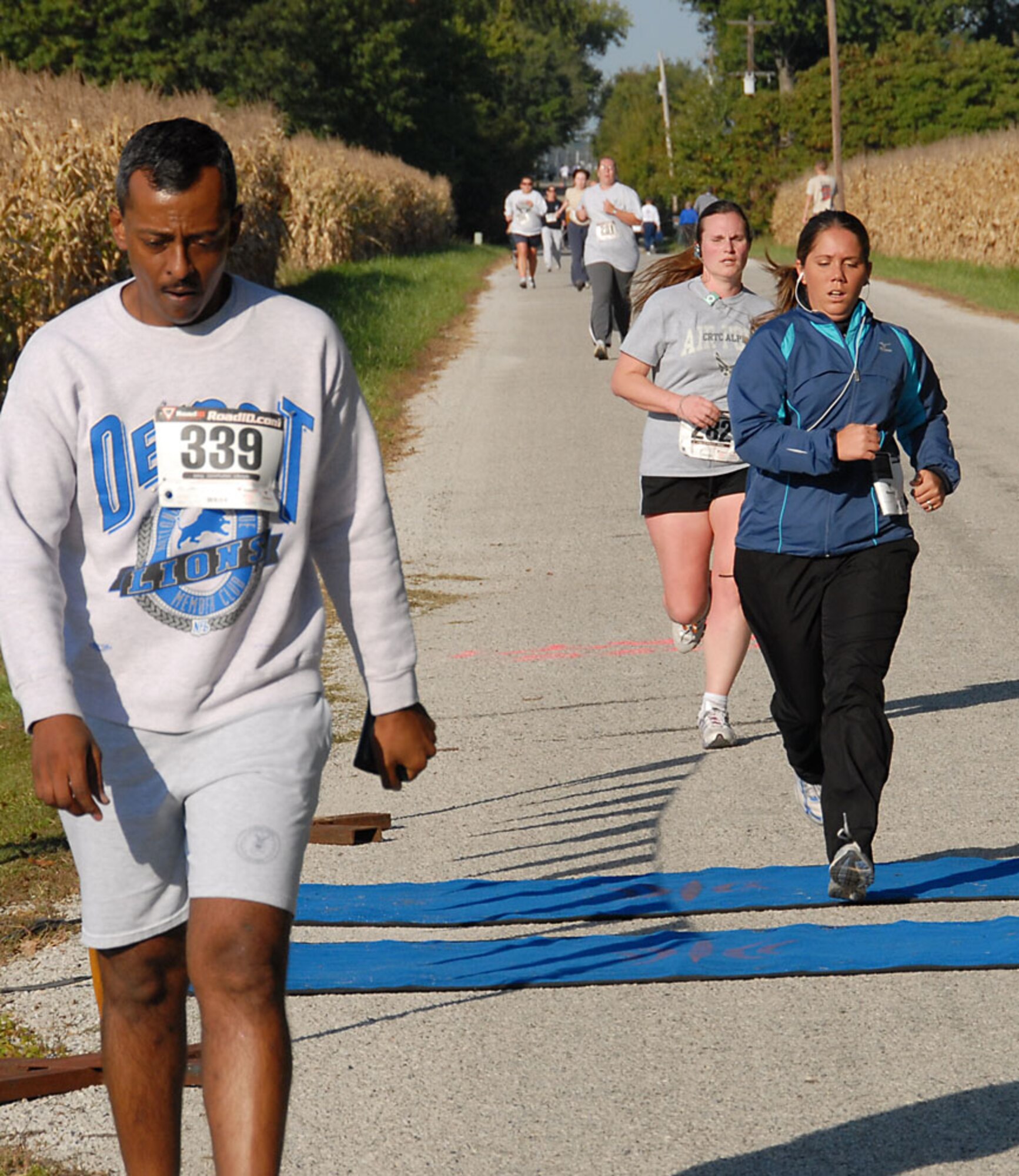 Members push hard as they near the timing carpet to complete their 1.5 mile “Fun Run”.