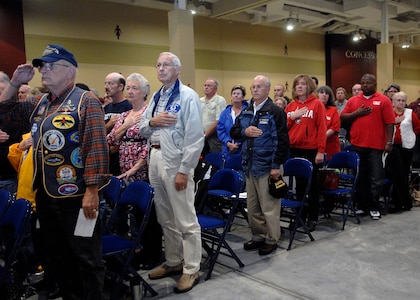 Attendees stand for the National Anthem during the closing ceremony for The Moving Wall display at the North Charleston Performing Arts Center in North Charleston, S.C., Oct. 18. Airmen, Sailors, Soldiers, Marines and Coast Guardsmen stood watch 24 hours a day from Oct. 16 to 20 at the wall which is a half-size replica of the Vietnam Veterans National Memorial, The Wall, located in Washington, D.C. (U.S. Air Force photo/Airman 1st Class Katie Gieratz)
