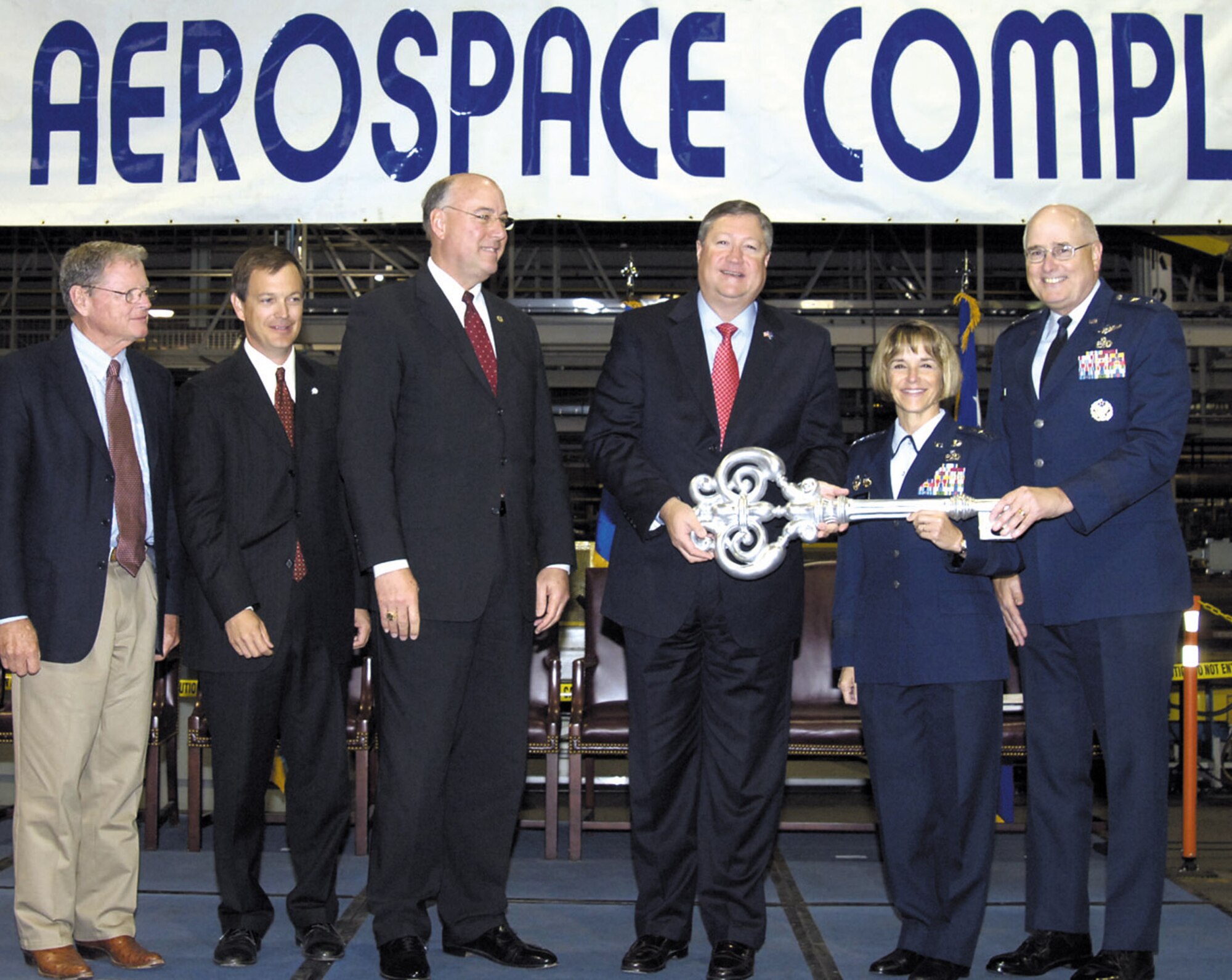 Secretary of the Air Force Michael B. Donley, center right, Lt. Gen. Terry Gabreski, Air Force Materiel Command vice commander, and Maj. Gen. Loren Reno, Oklahoma City Air Logistics Center commander, hold the ceremonial key to the Tinker Aerospace Complex after it was presented by Oklahoma County Commissioner Ray Vaughn, center left, during a recognition ceremony here Thursday. Also participating in the ceremony are, from left, U.S. Senator James Inhofe and Oklahoma State Treasurer Scott Meacham. More than 200 people attended the event, recognizing the Air Force’s signing of a low-cost, long-term lease with Oklahoma County for use of the former General Motors facility on Sept. 24. Look for additional coverage of the event in next week’s Tinker Take Off. (Air Force photo/Margo Wright)
