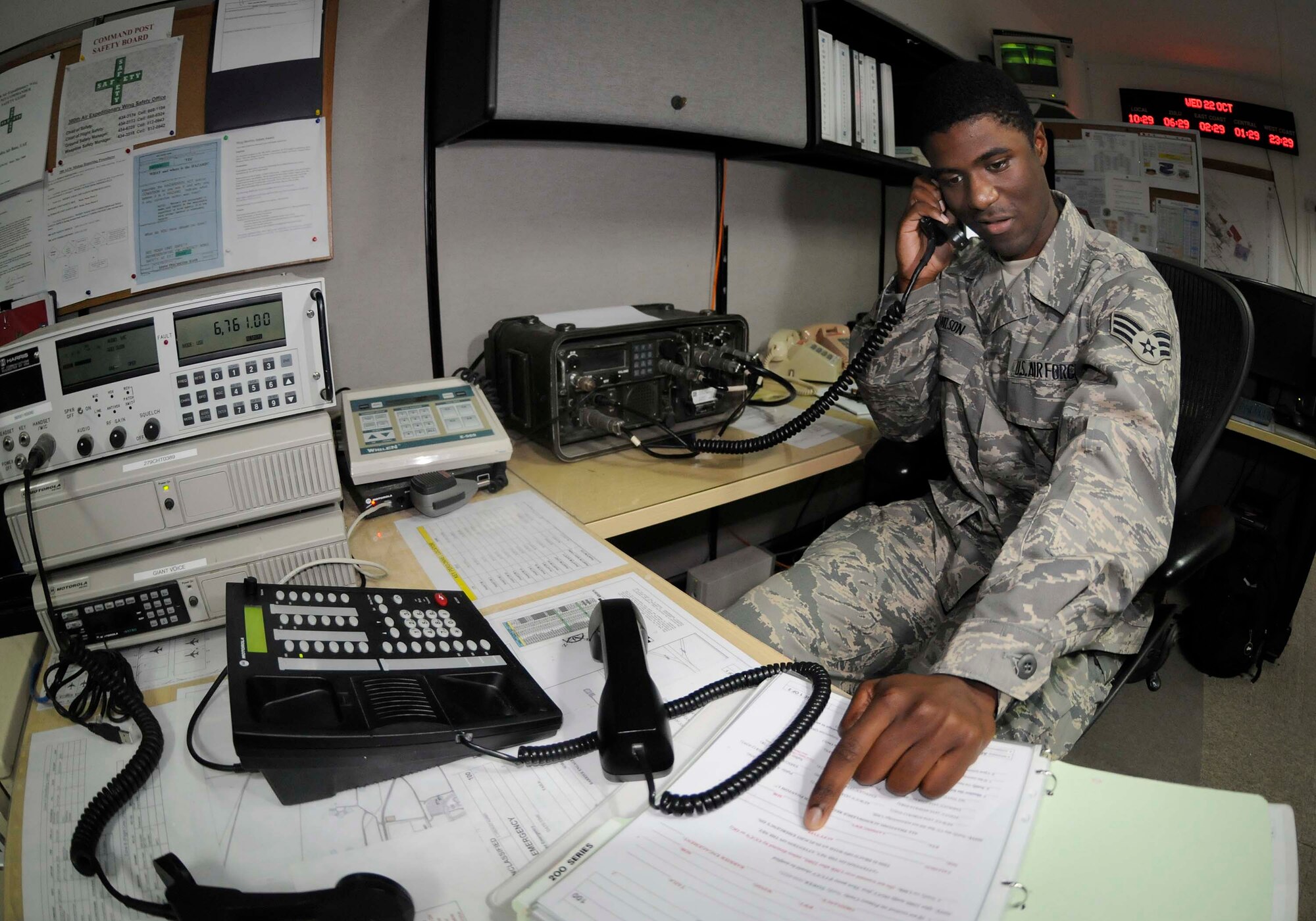 SOUTHWEST ASIA -- Senior Airman Paul Wilson, Jr., emergency actions controller with the 380th Air Expeditionary Wing Command Post, relays vital information to commanders and first responders during in-flight emergencies. Airman Wilson is deployed from the 52nd Fighter Wing, Spangdahlem Air Base, Germany. (Photo by 1st Lt. Michael V. Frye/Released)