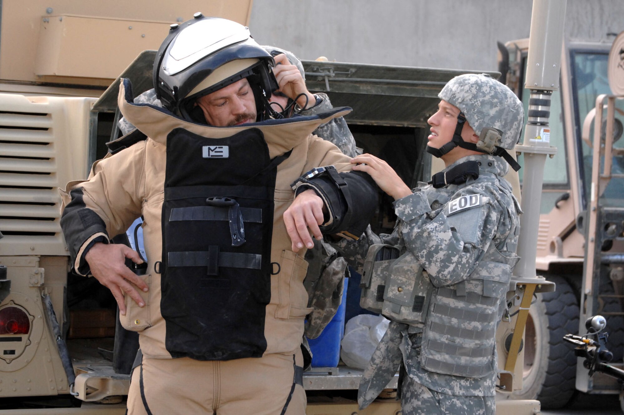 Senior Airman William Therisault and Staff Sgt. Roger Hughes dress out Tech. Sgt. Michael Shumate into an Explosive Ordnance Disposal bomb suit as he powers up the environmental control unit at Kirkuk Regional Air Base, Iraq, Oct. 21.  The three Airmen of the 506th Expeditionary Civil Engineer Squadron EOD were responding to a suspicious package call on the flightline.  Airman Theriault is deployed from Davis-Monthan Air Force Base, Ariz., and calls Calis, Maine home.  Sergeant Hughes is deployed from Shaw AFB, S.C., and calls Charleston, W.Va., home.  Sergeant Shumate is deployed from Whiteman AFB, Mo., and calls Winston-Salem, N.C., home. (U.S. Air Force photo/Senior Airman Randi Flaugh)