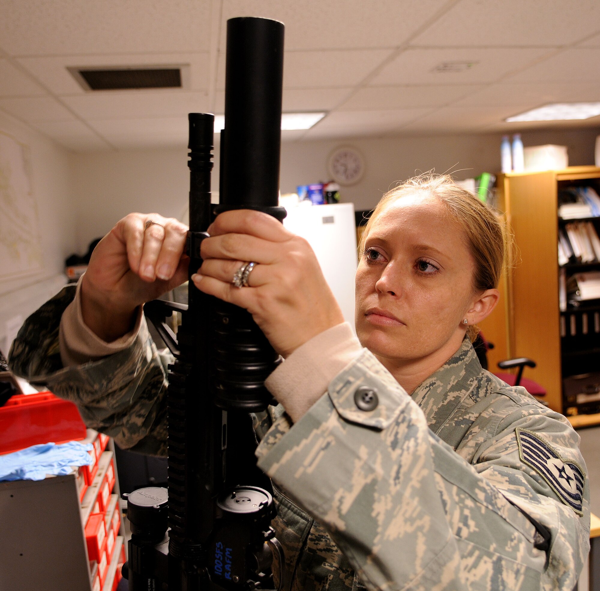 Tech. Sgt. Tisha Bate a 100th Security Forces Squadron armorer,  attaches an M203 grenade launcher to an M4 assault rifle at the RAF Mildenhall armory Oct. 21, 2008. All military members who own firearms are required to keep them stored at the armory. Additionally armorors issue and deploy government weapons to military members whose job requires them, performing routine inspections and basic maintenance. (U.S. Air Force photo by Staff Sgt. Jerry Fleshman)