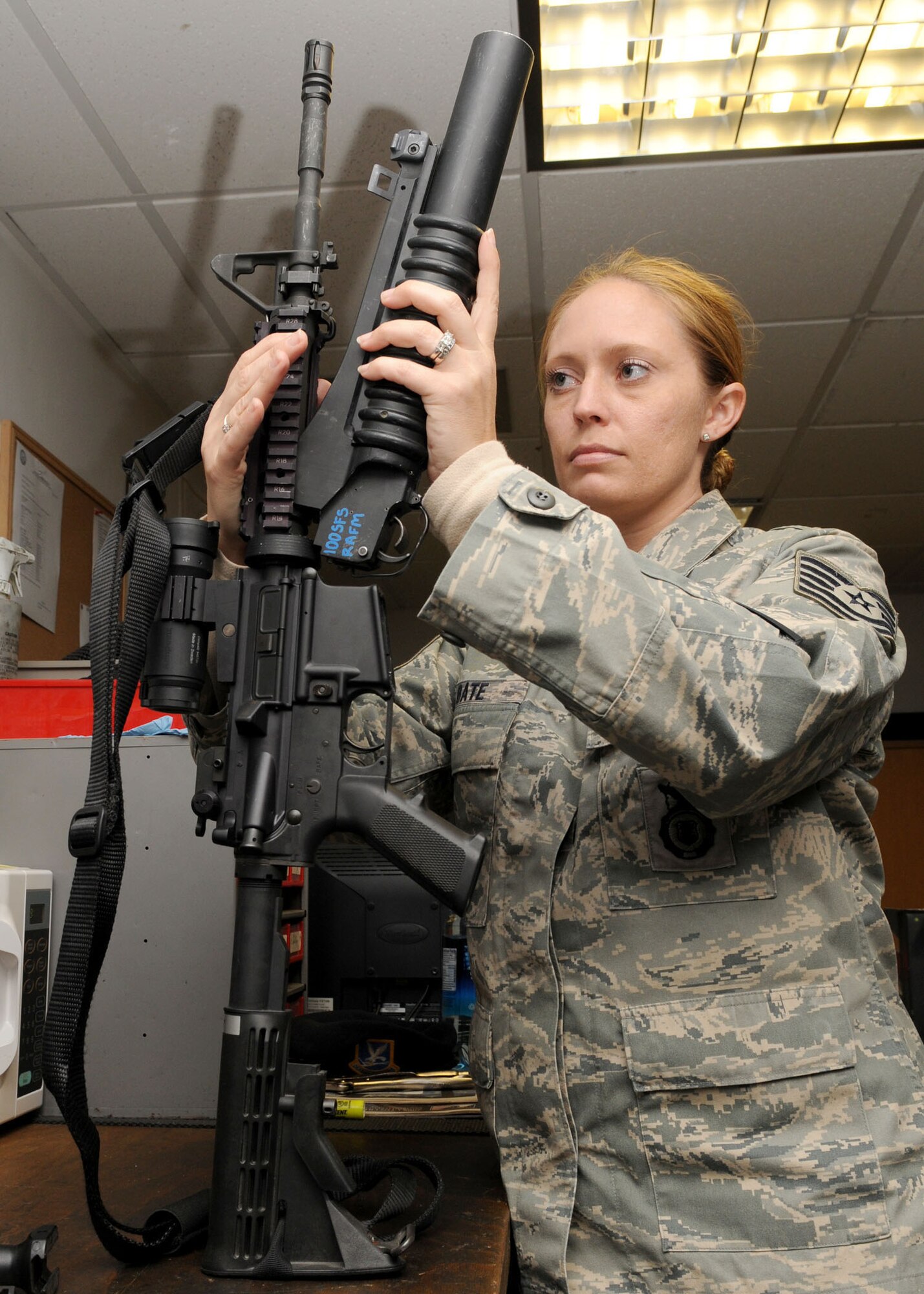 Tech. Sgt. Tisha Bate a 100th Security Forces Squadron armorer,  attaches an M203 grenade launcher to an M4 assault rifle at the RAF Mildenhall armory Oct. 21, 2008. All military members who own firearms are required to keep them stored at the armory. Additionally armorors issue and deploy government weapons to military members whose job requires them, performing routine inspections and basic maintenance. (U.S. Air Force photo by Staff Sgt. Jerry Fleshman)