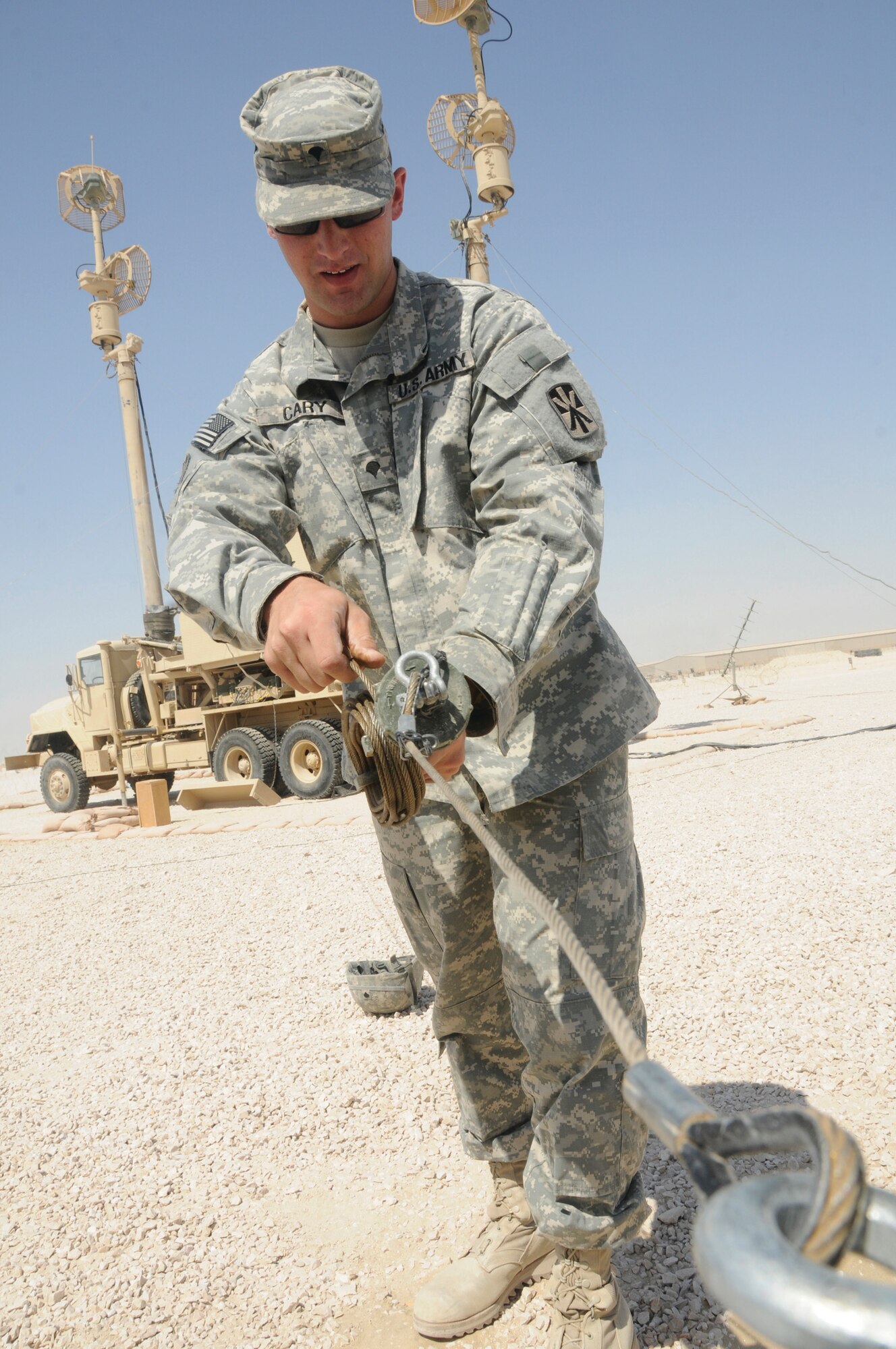 Specialist John Cary, radio transmission systems operator maintainer assigned to Alpha 2-43, anchors guide wires to stabilize an antenna mast. (U.S. Air Force photo by Staff Sgt. Darnell T. Cannady)